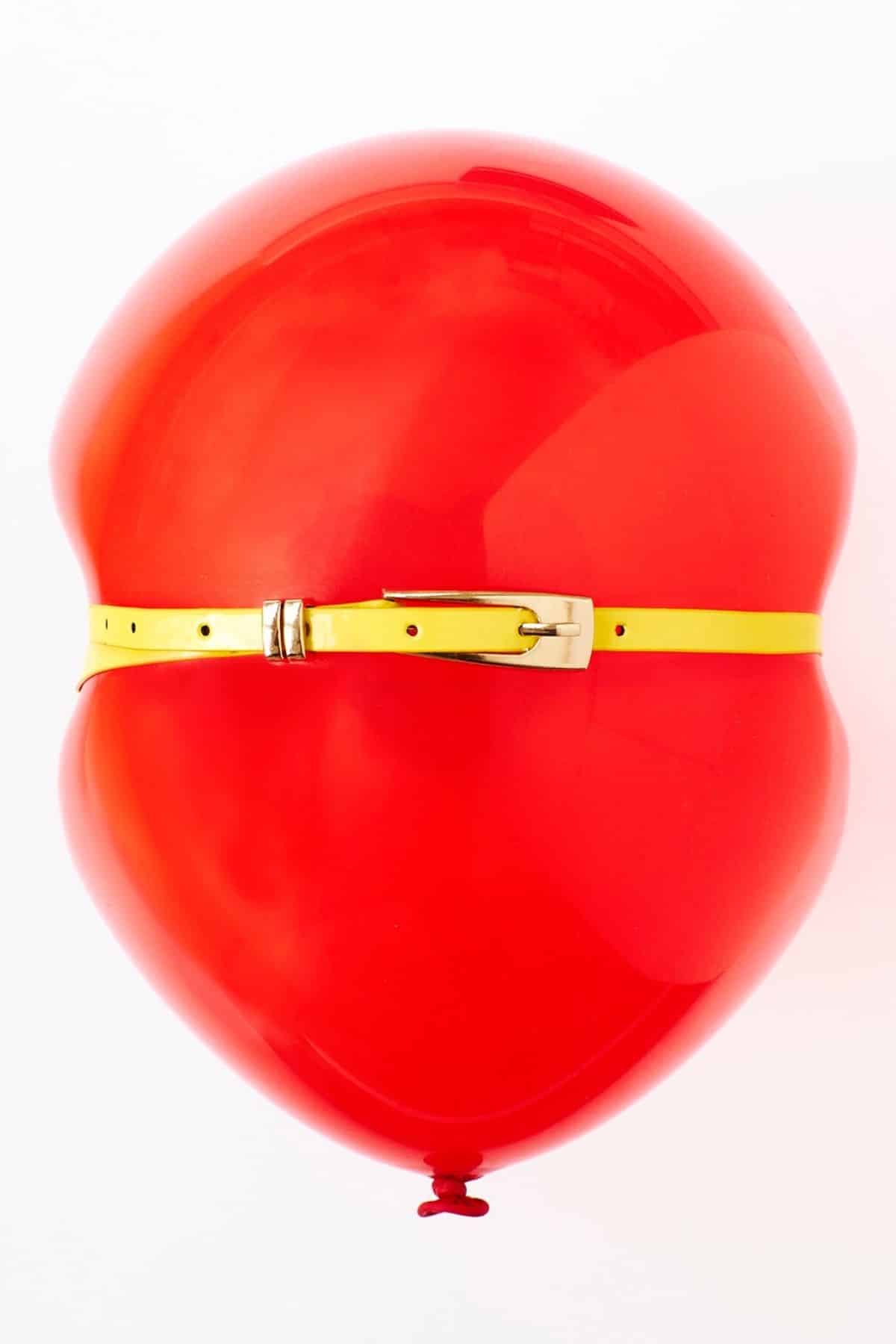 red balloon with a yellow belt around the middle of it