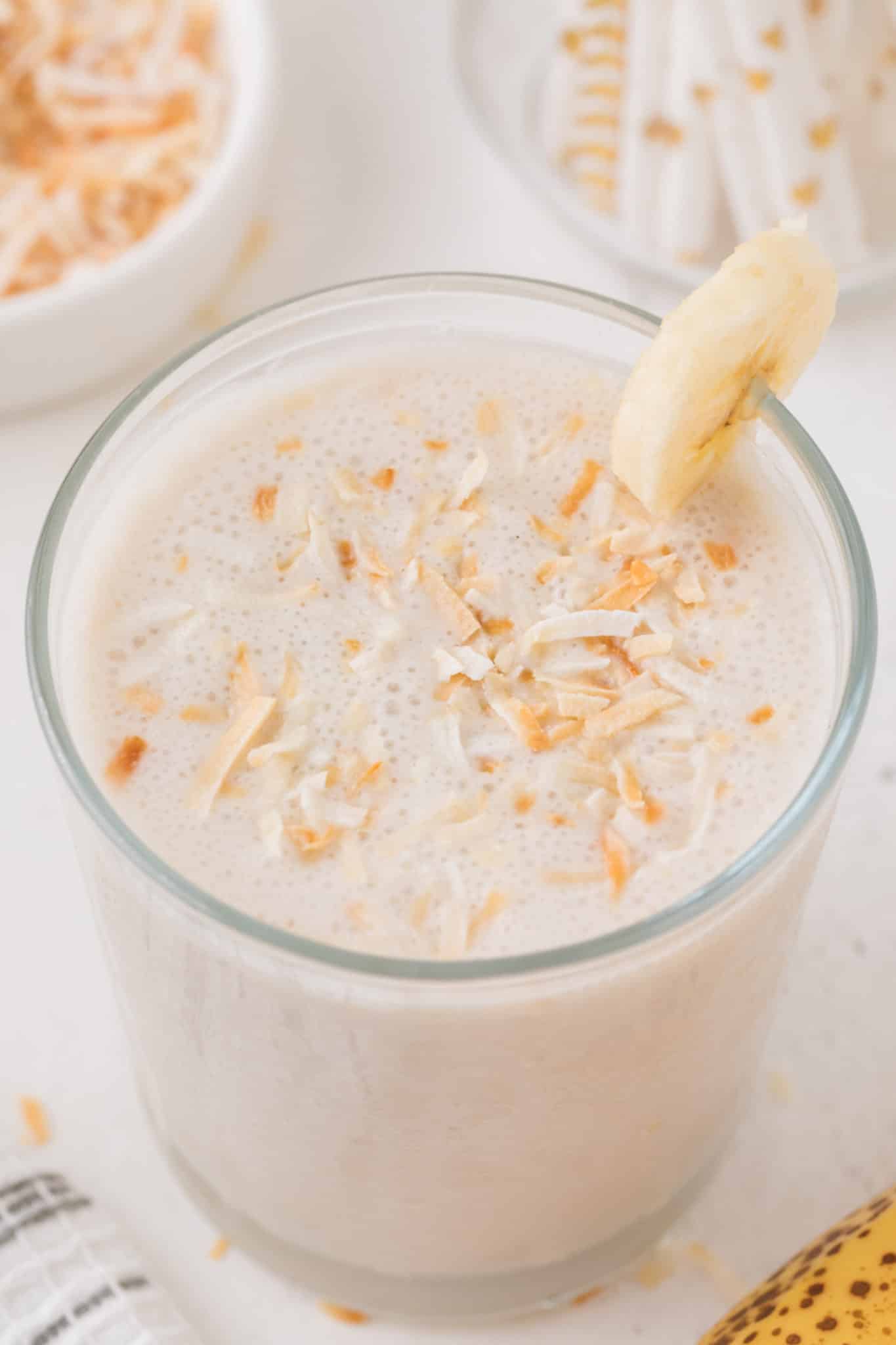 coconut shake in a glass with toasted coconut on top.