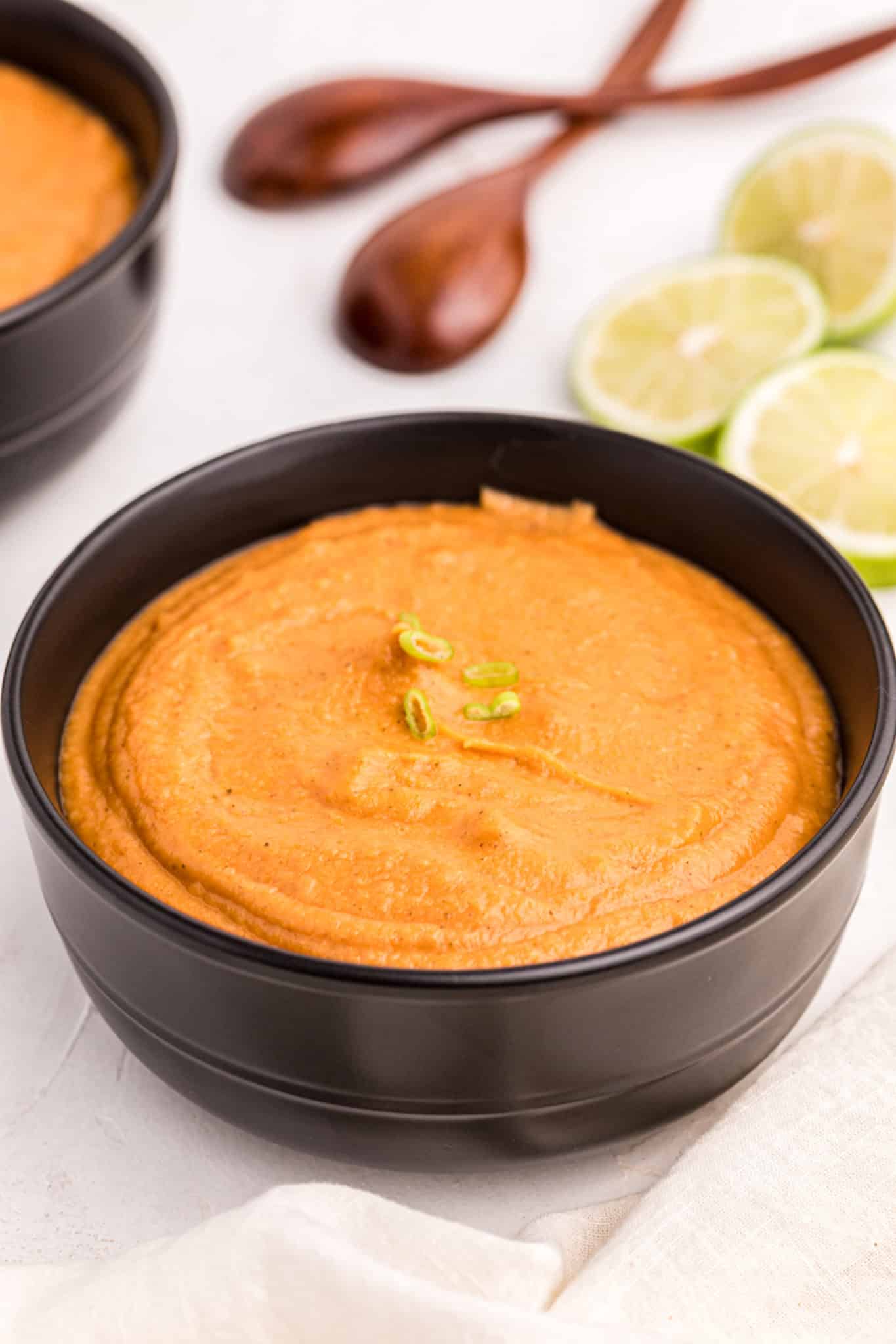 peanut butter soup served in a black bowl.