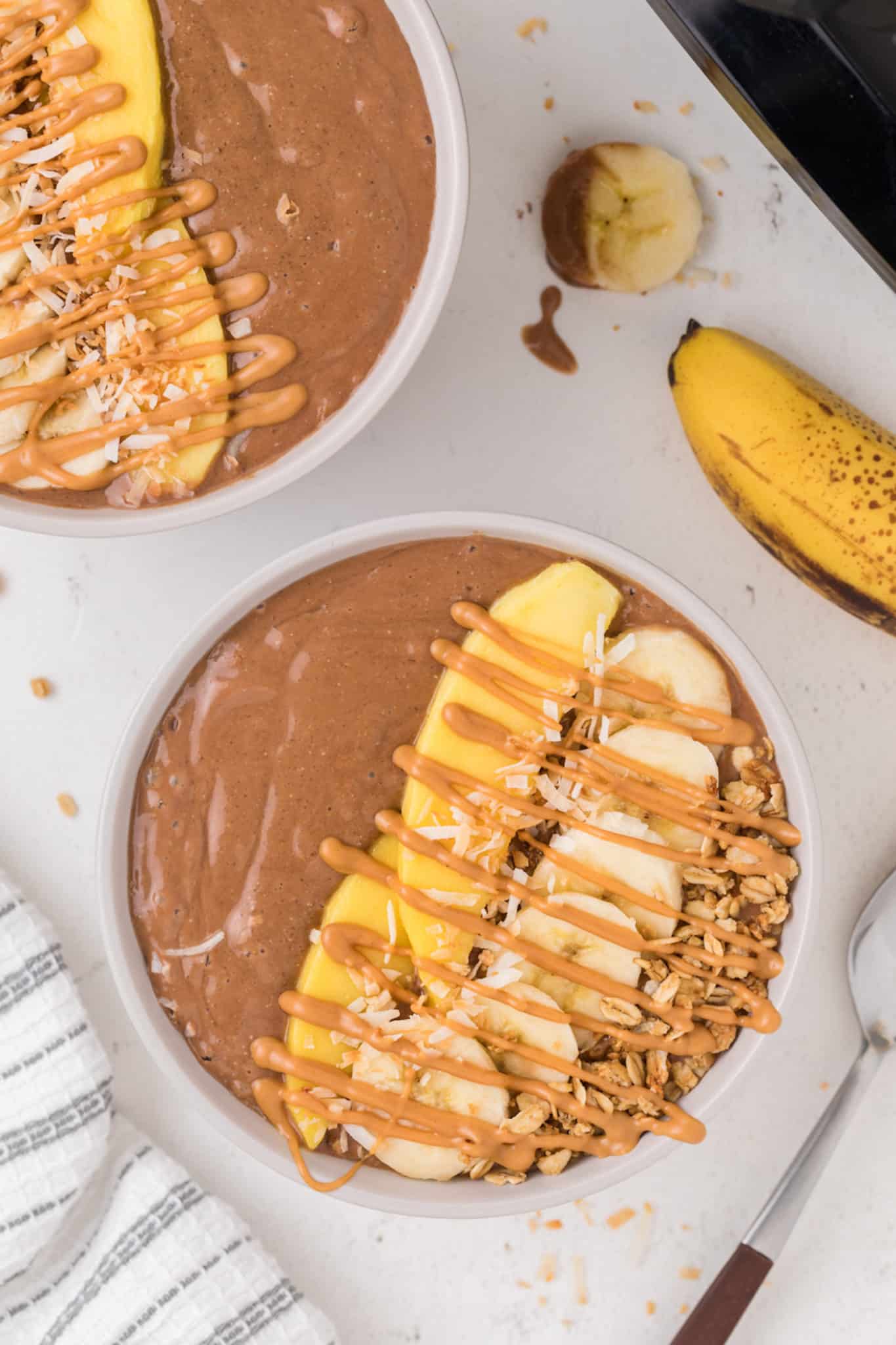 chocolate smoothie bowls topped with mango and bananas.