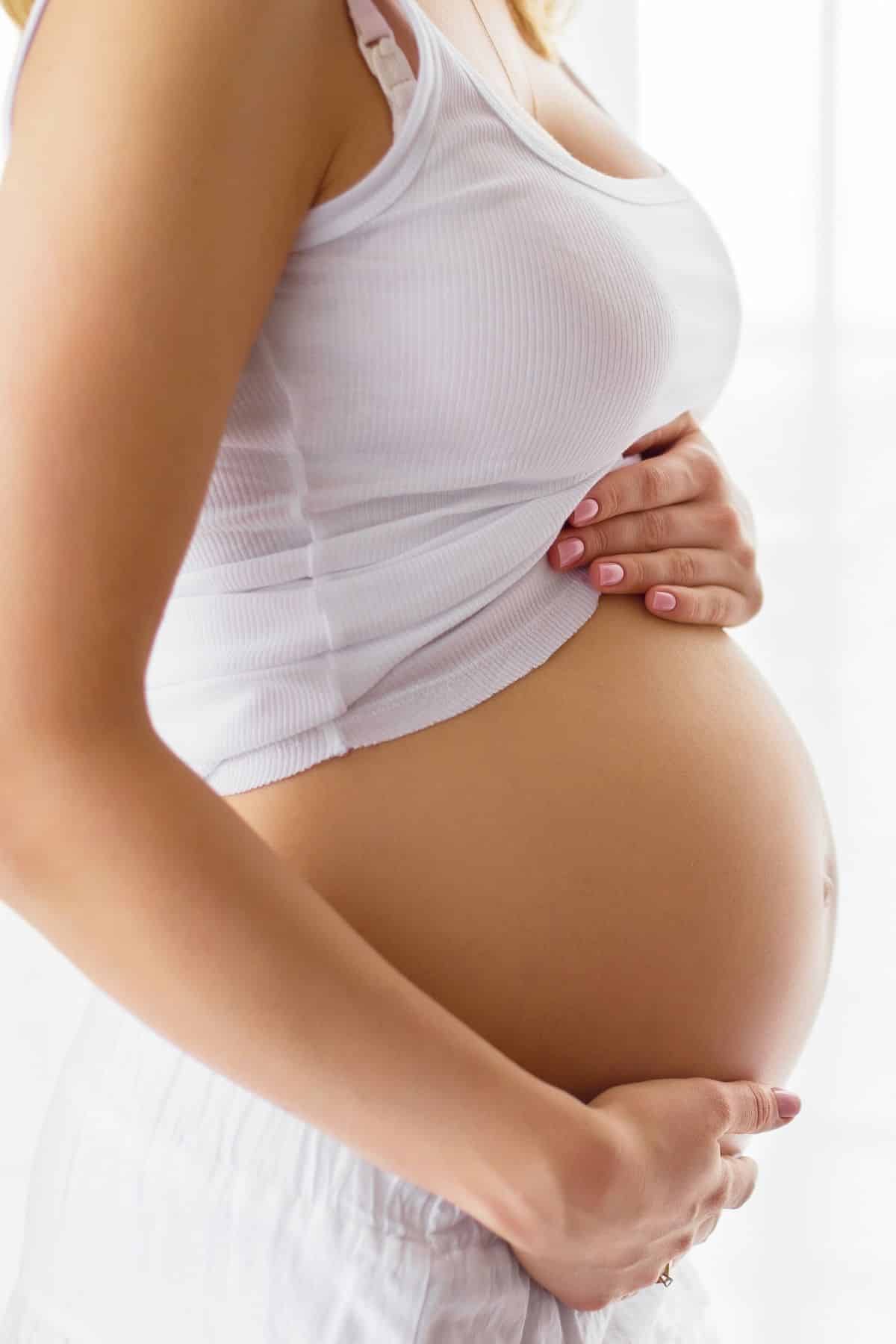 pregnant woman holding her belly.