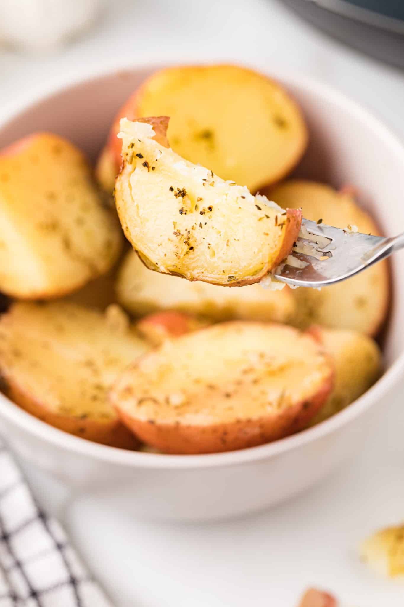 picture of a fork with a piece of cooked instant pot red potato on it.