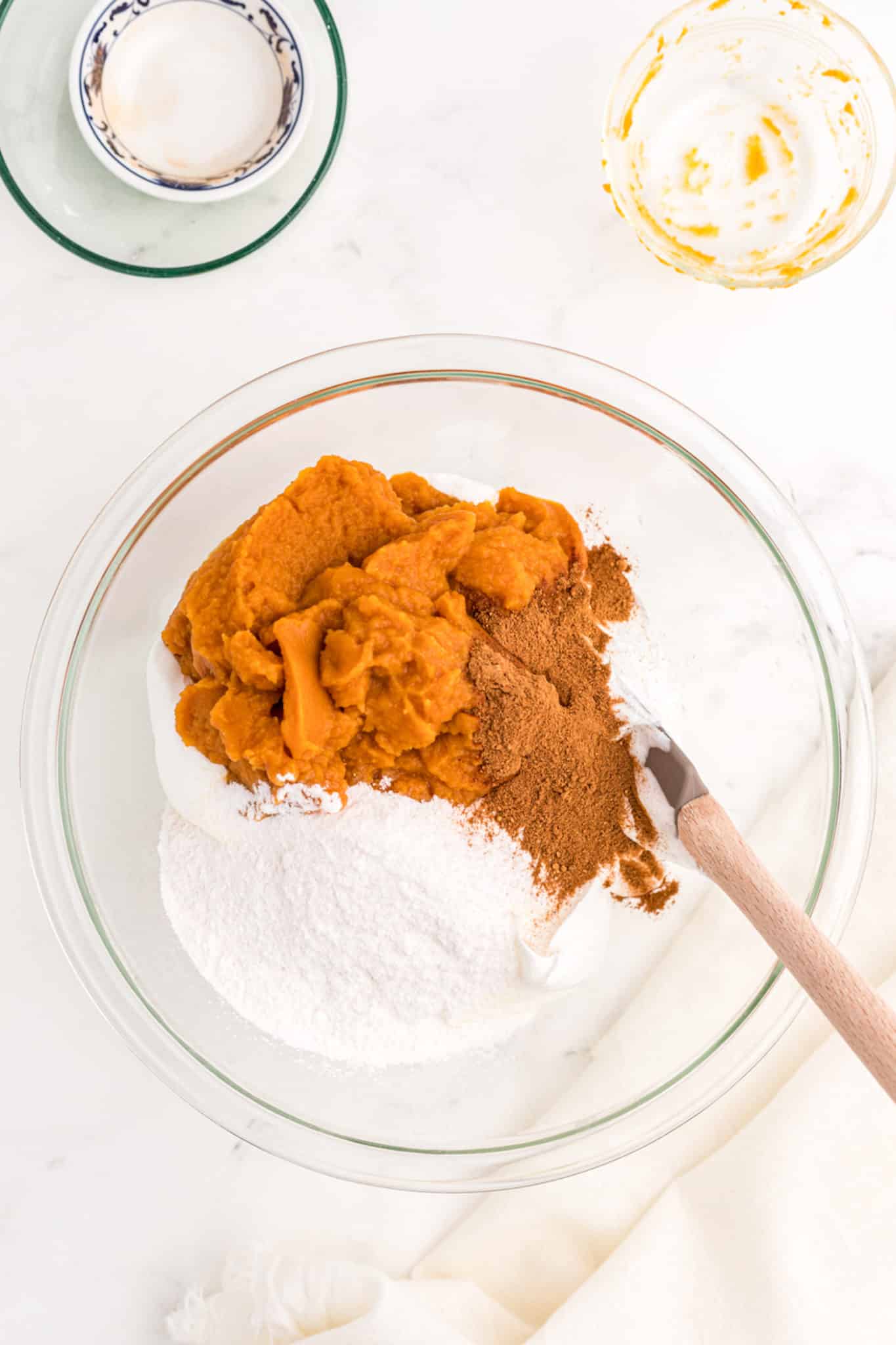 a bowl of whipped topping, spices, and pumpkin puree