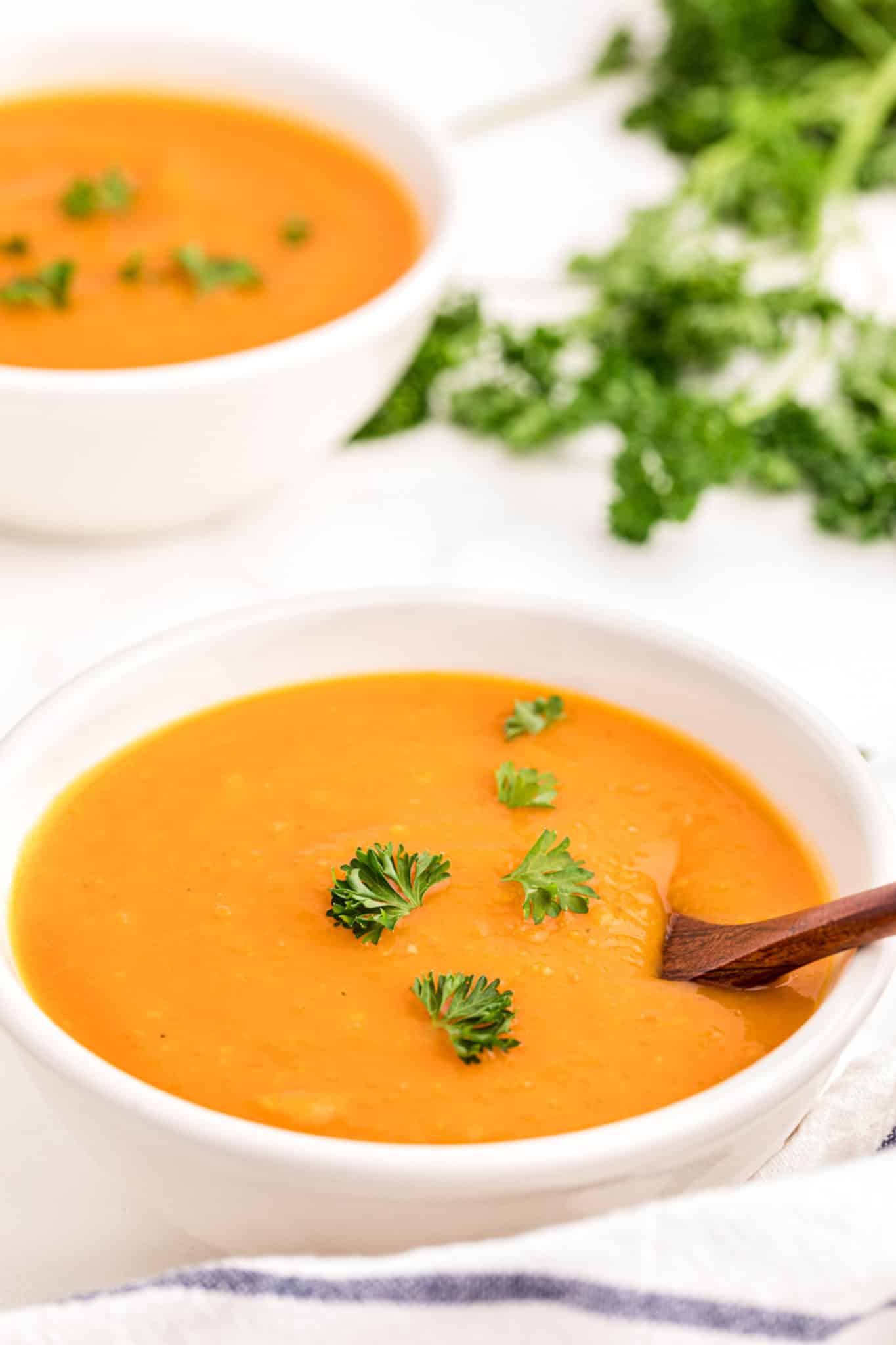 butternut squash soup served in two white bowls.