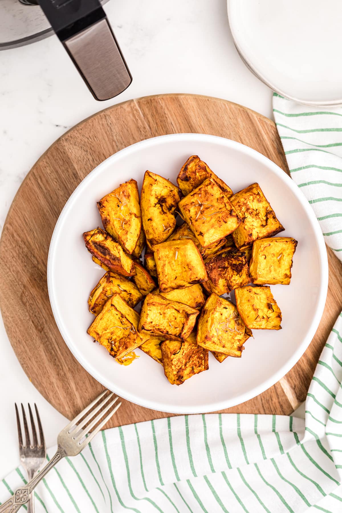 roasted pumpkin chunks served in a white bowl.