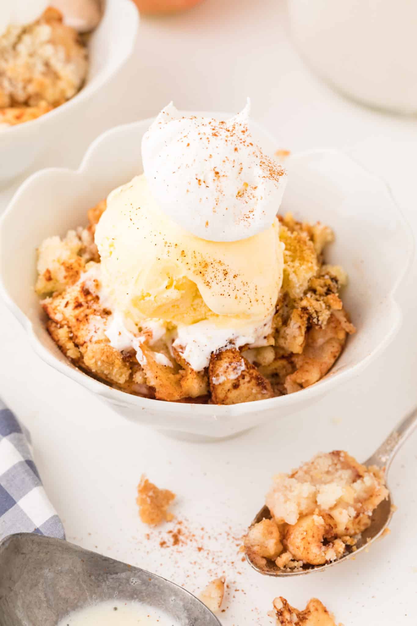 apple crisp with ice cream and whipped cream.