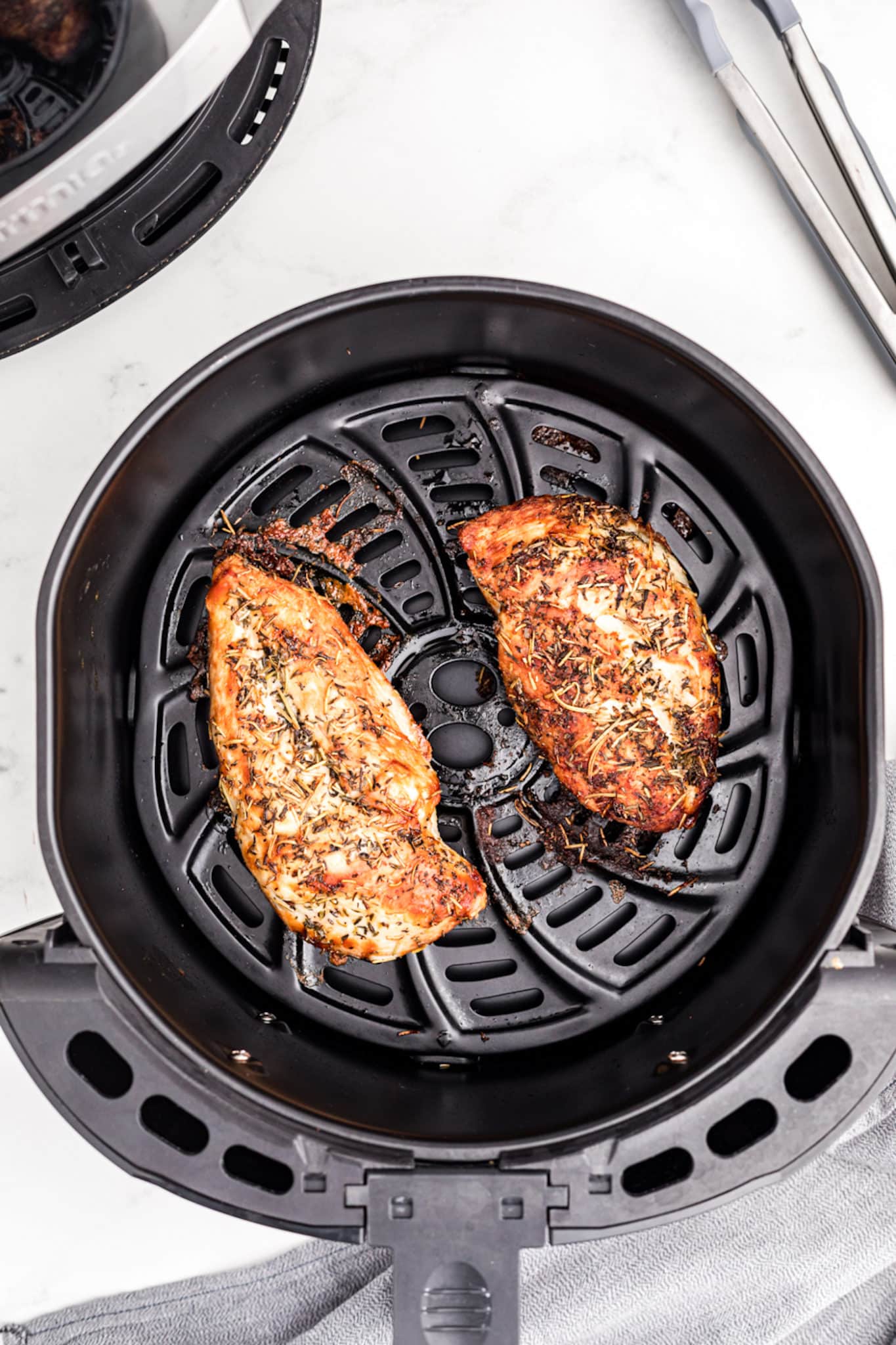 cooked turkey tenderloins in air fryer basket.