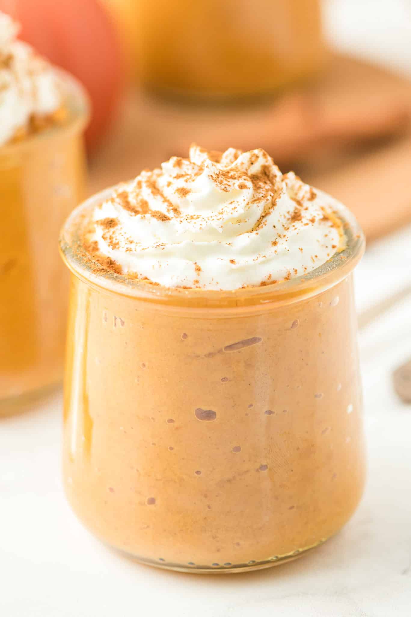 dairy free healthy pumpkin pudding with coconut whipped cream on top.