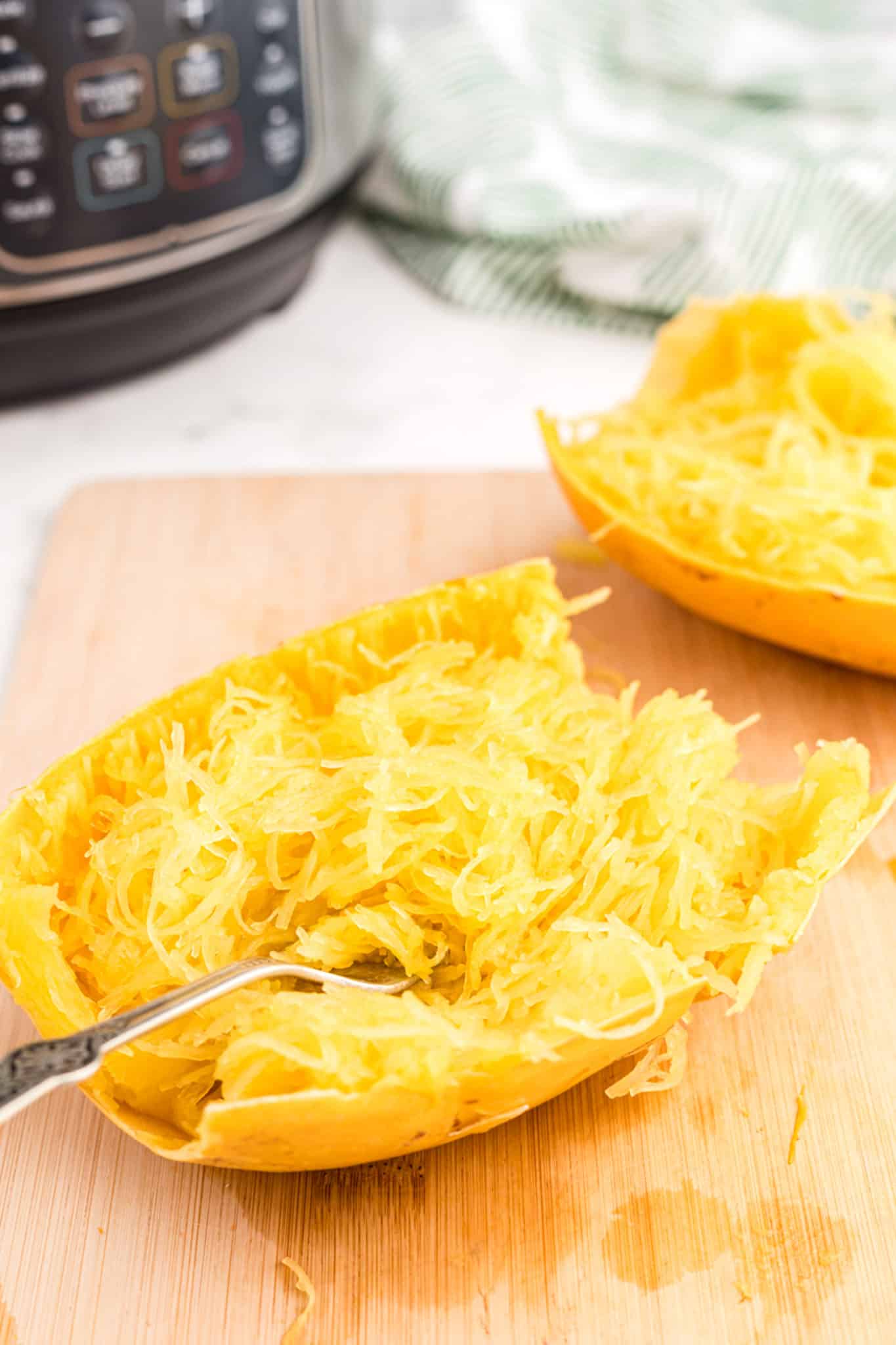 cooked instant pot spaghetti squash half on cutting board.