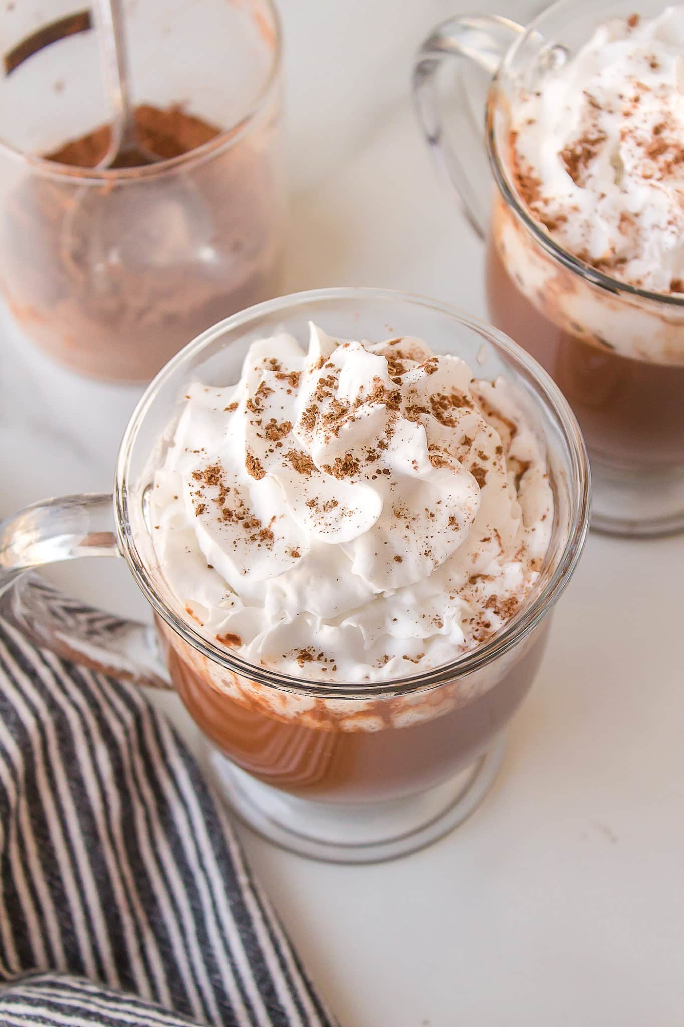 two mugs of hot chocolate with whipped cream.