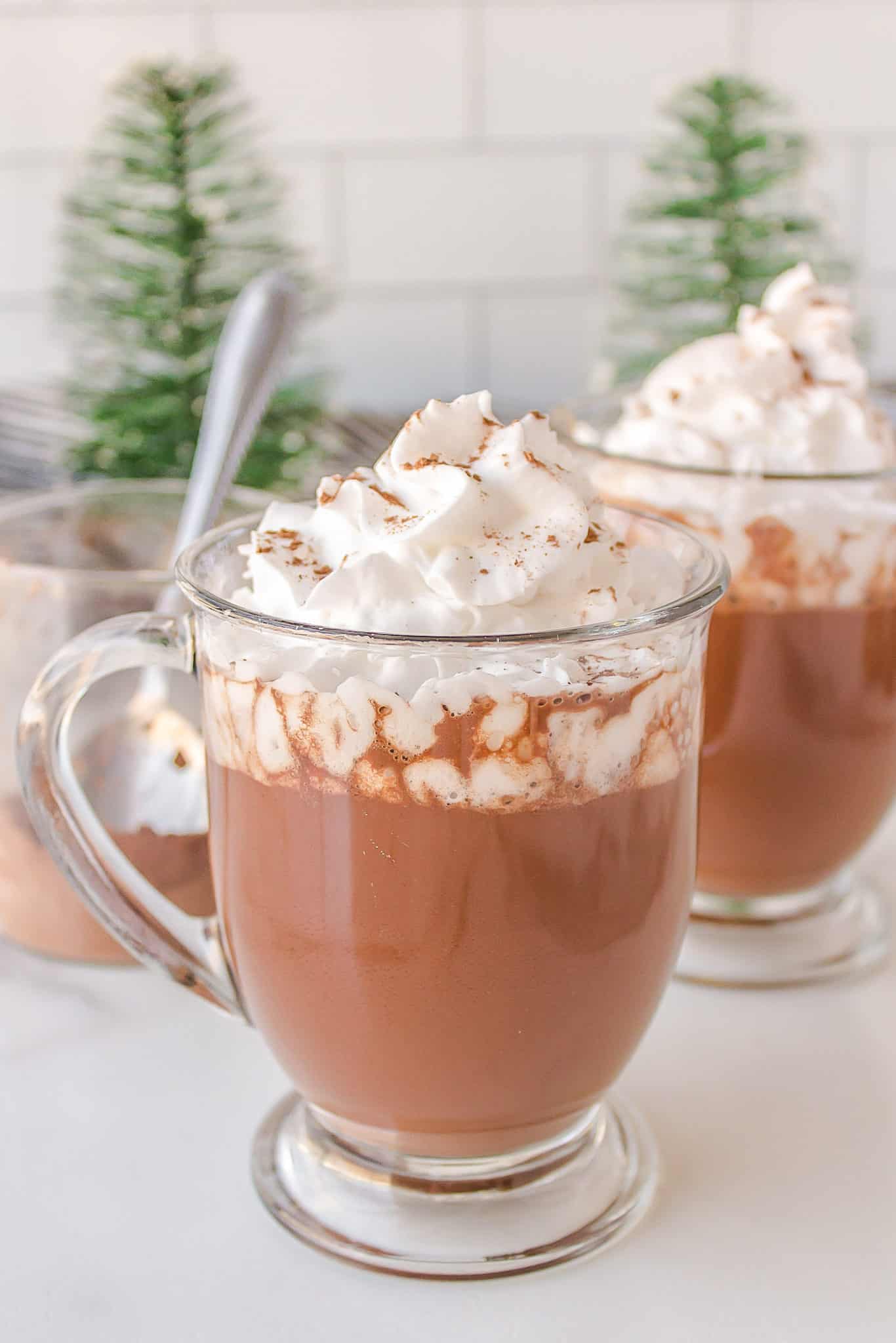 a cup of healthy oat milk hot cocoa with coconut whipped cream.