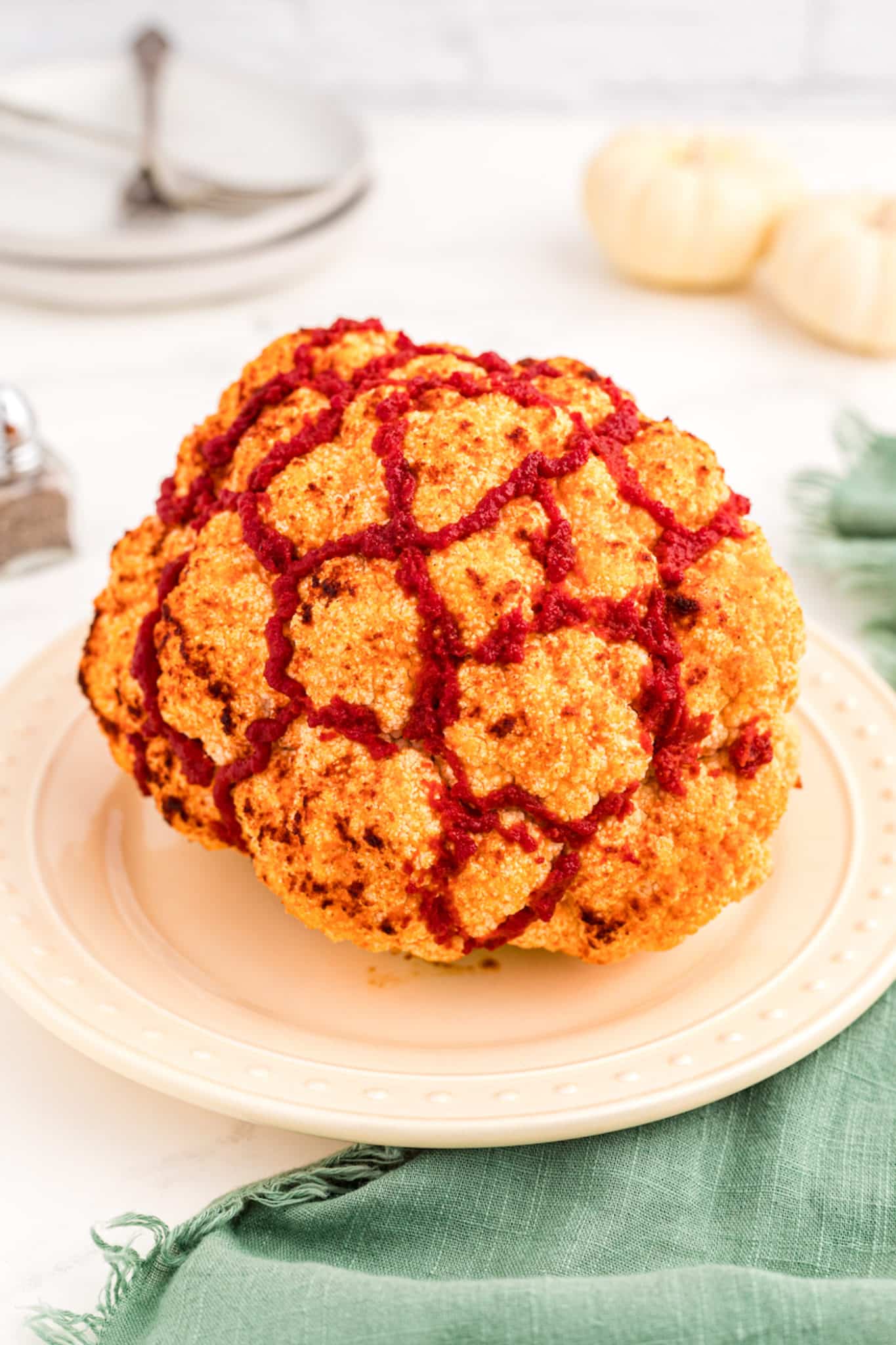 cooked whole cauliflower on a plate ready to serve.