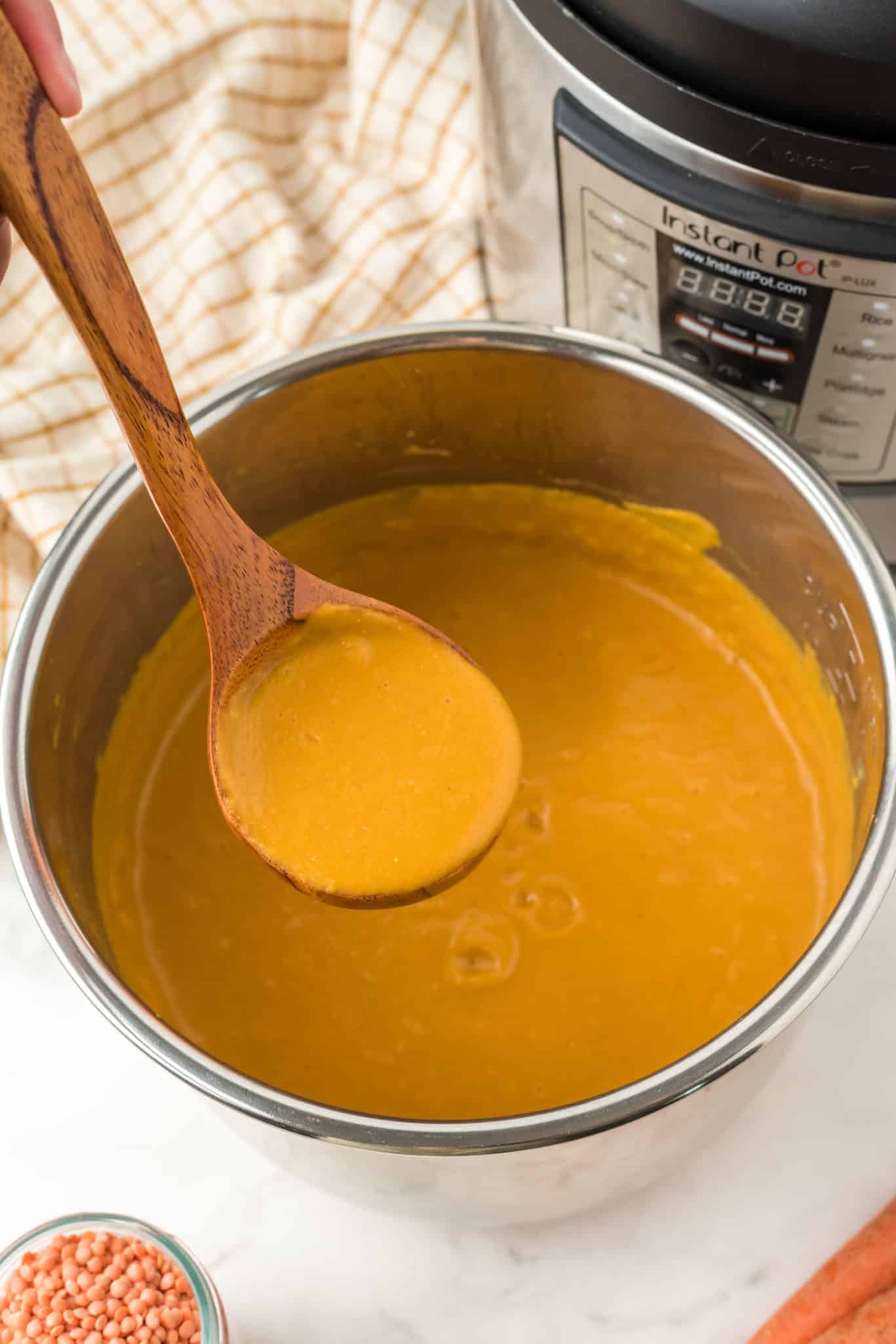 instant pot carrot ginger soup in a serving ladle. 