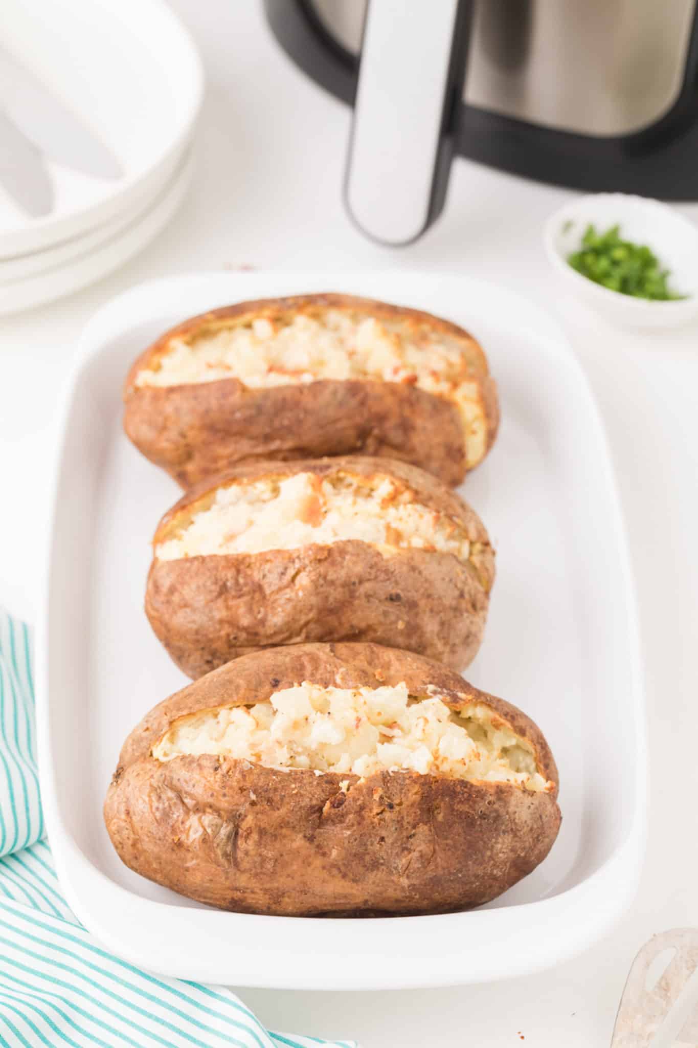 air fryer twice baked potatoes on white serving tray.