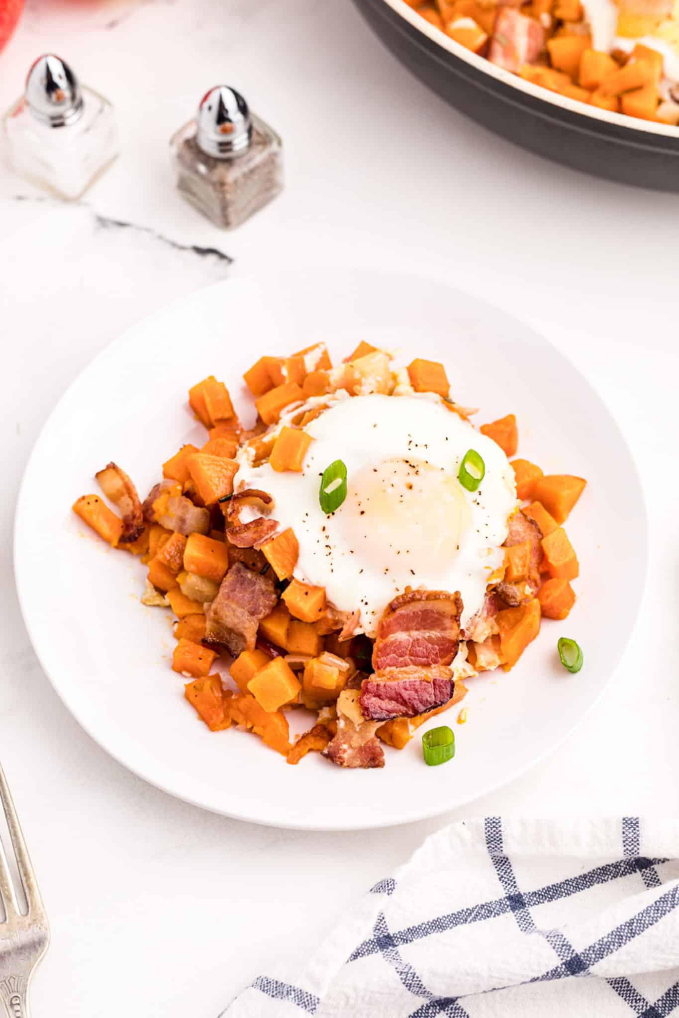 bowl of sweet potato hash with an egg on top