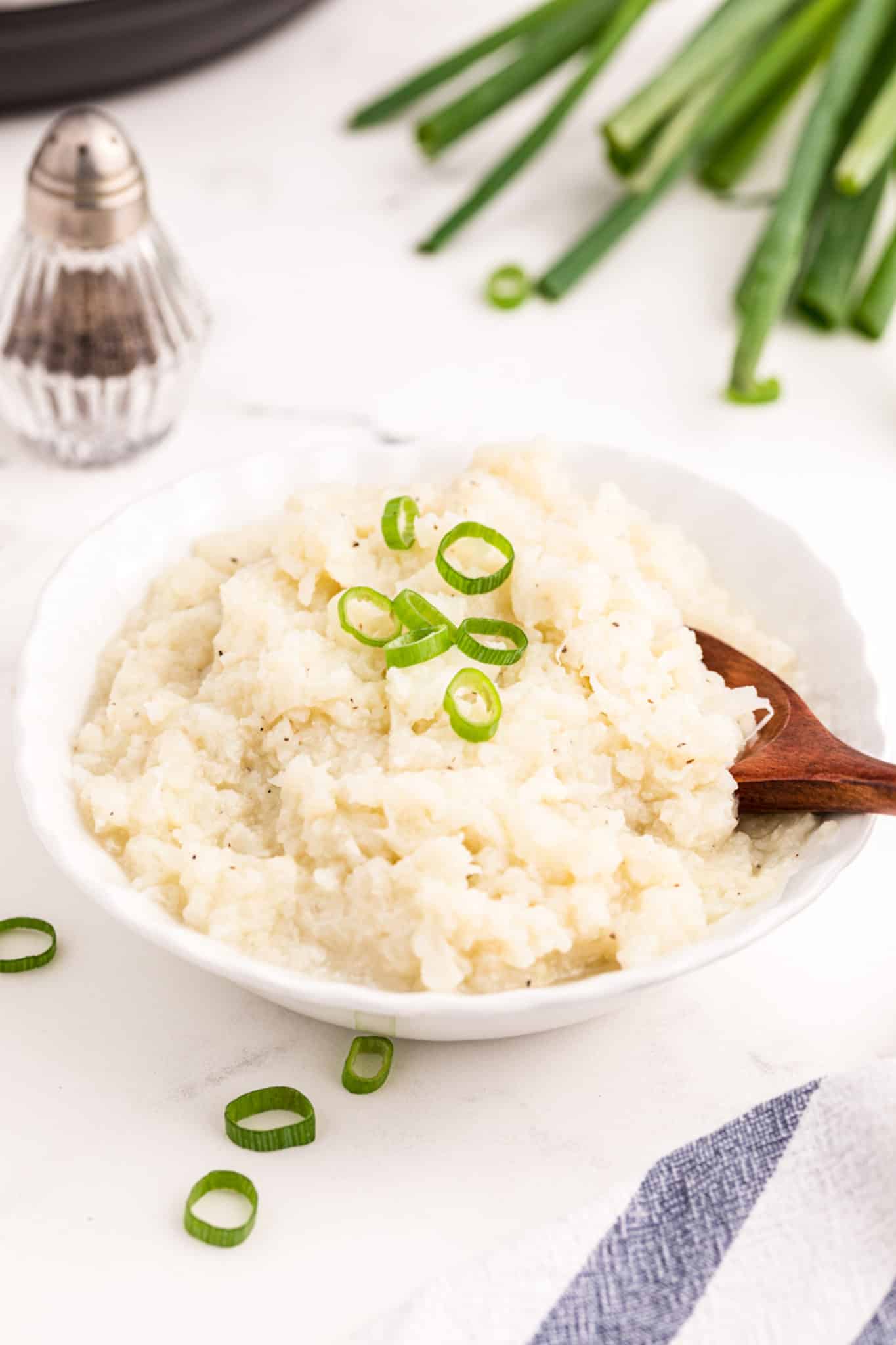 bowl of cooked instant pot cauliflower mash on a table.