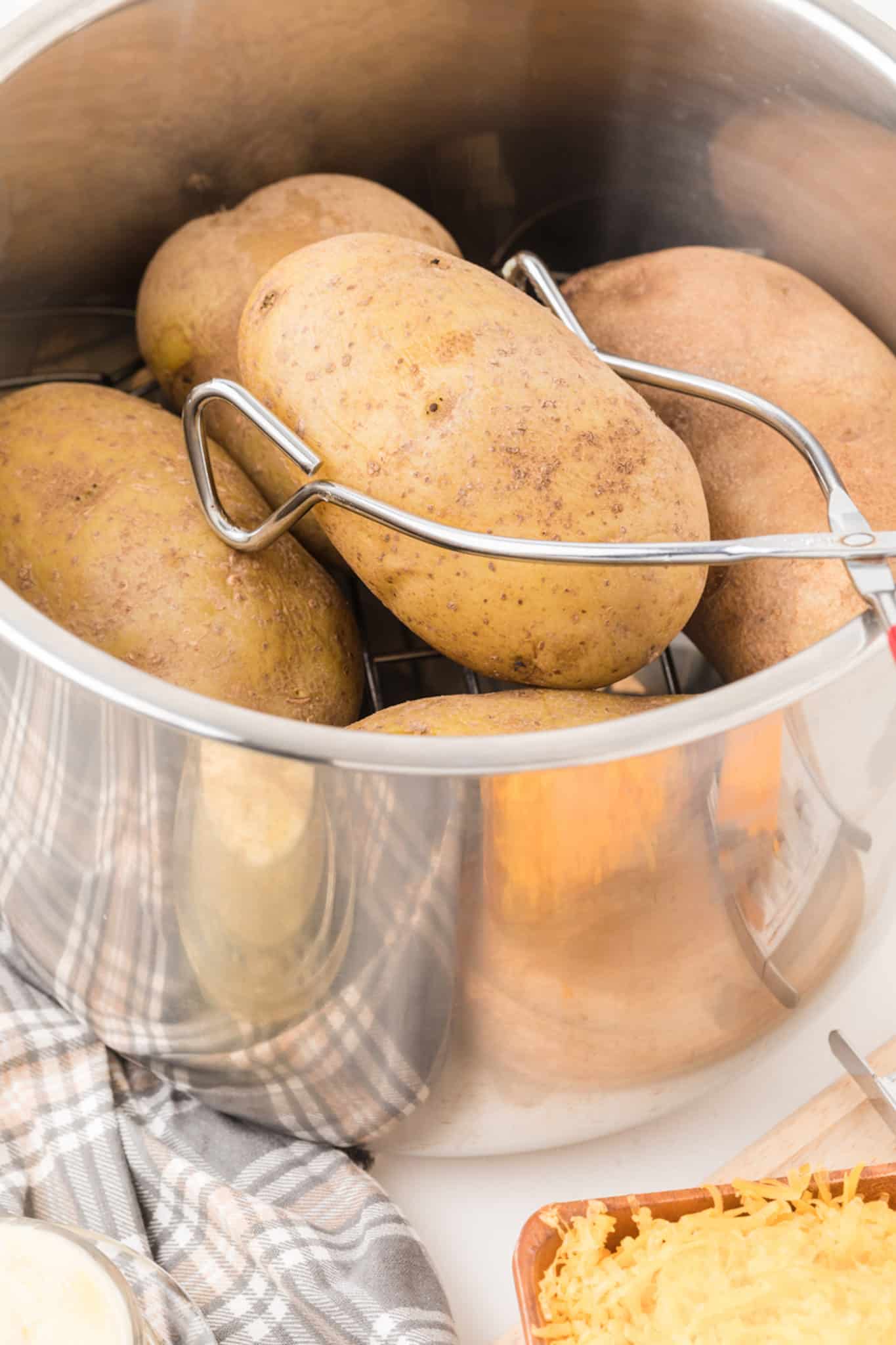 tongs removing a potato from the pot