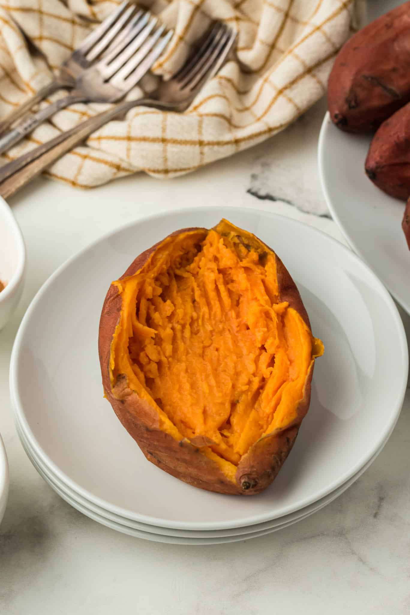 whole baked sweet potato on a plate.