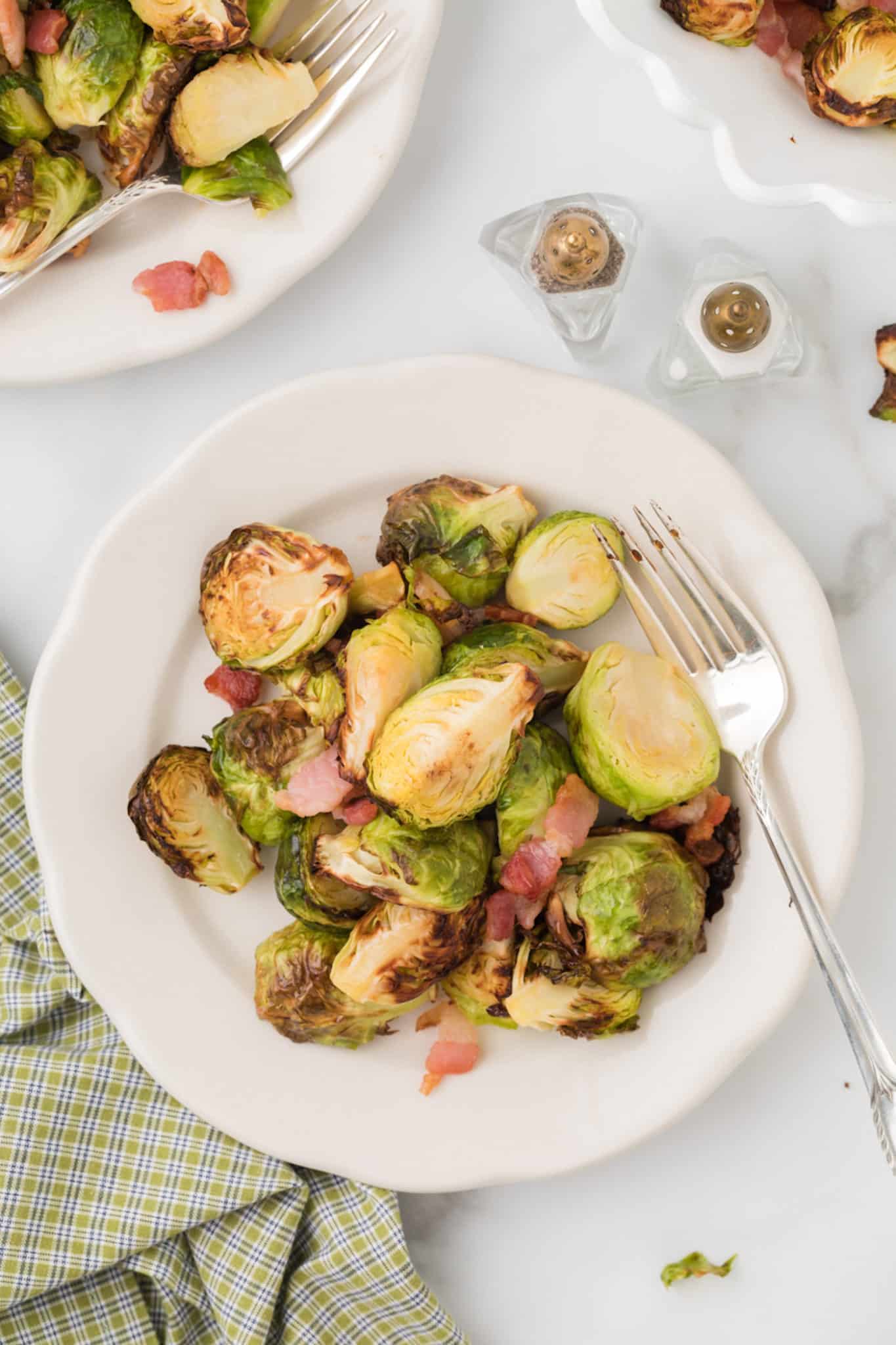 two plates with servings of brussel sprouts