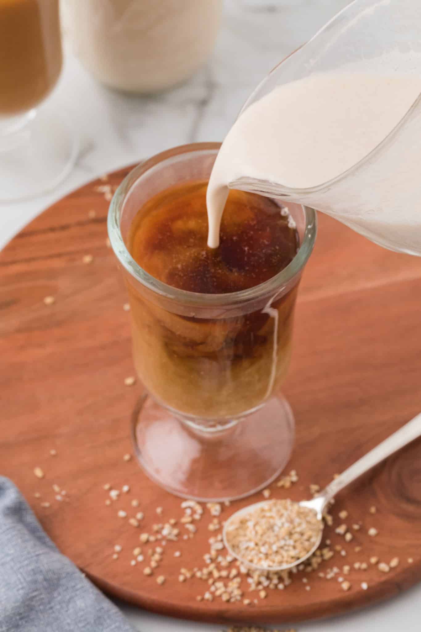 pouring oat milk into coffee.
