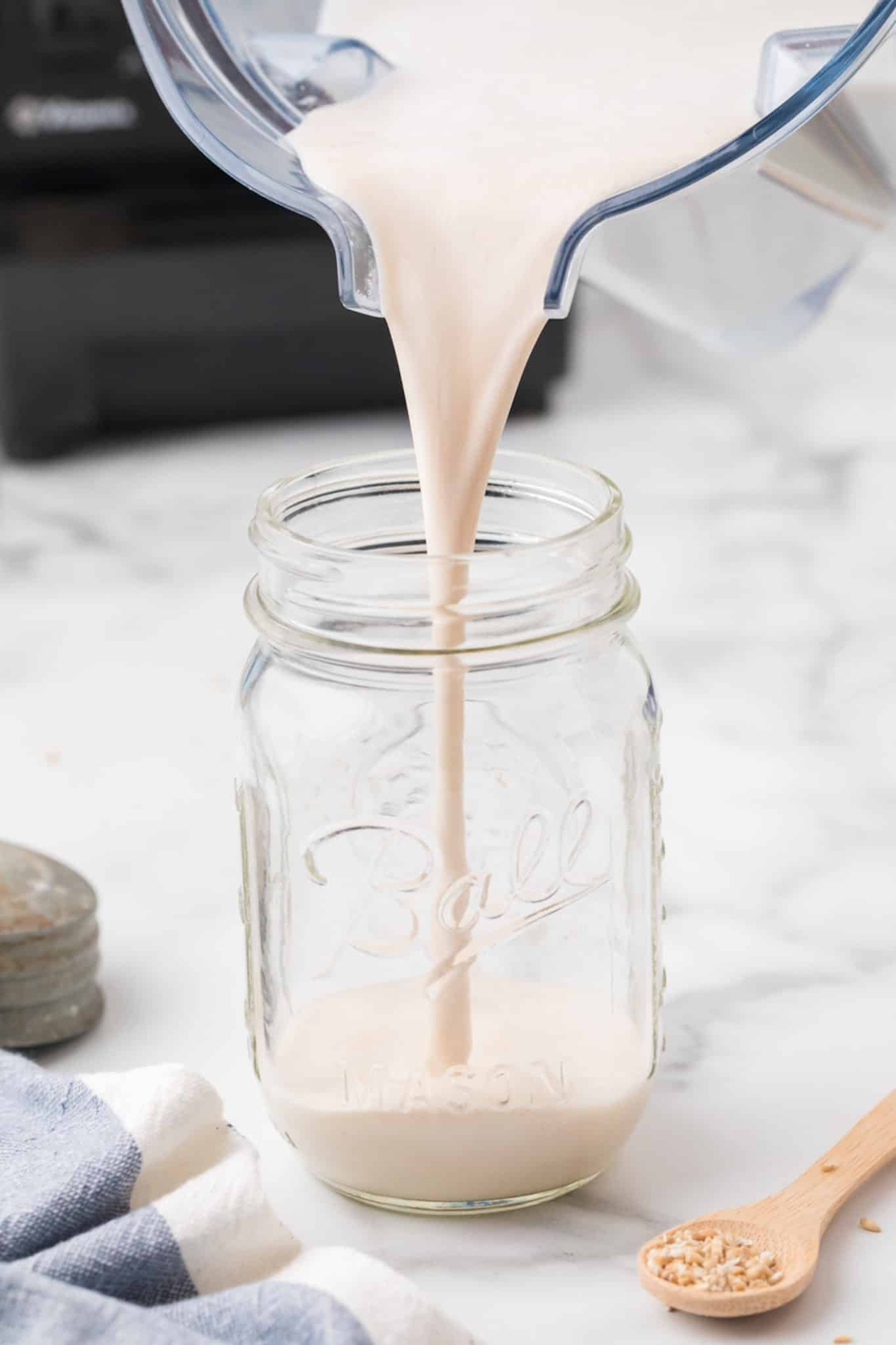 pouring oat milk recipe into jar.