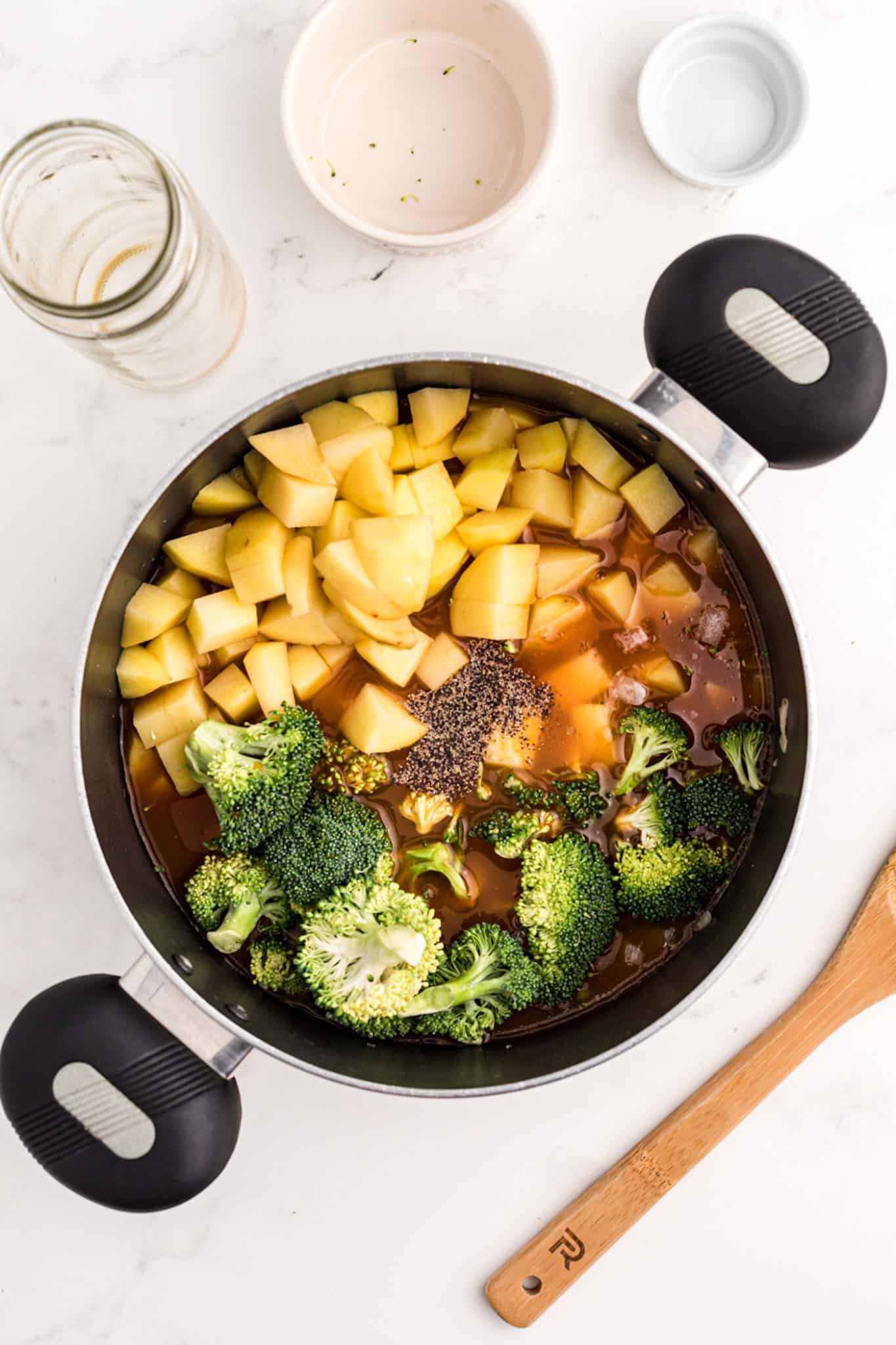 a pot of potatoes, broccoli, and broth.