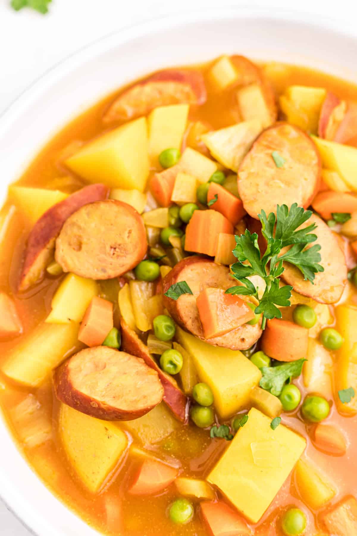 close up of curried sausages and carrots