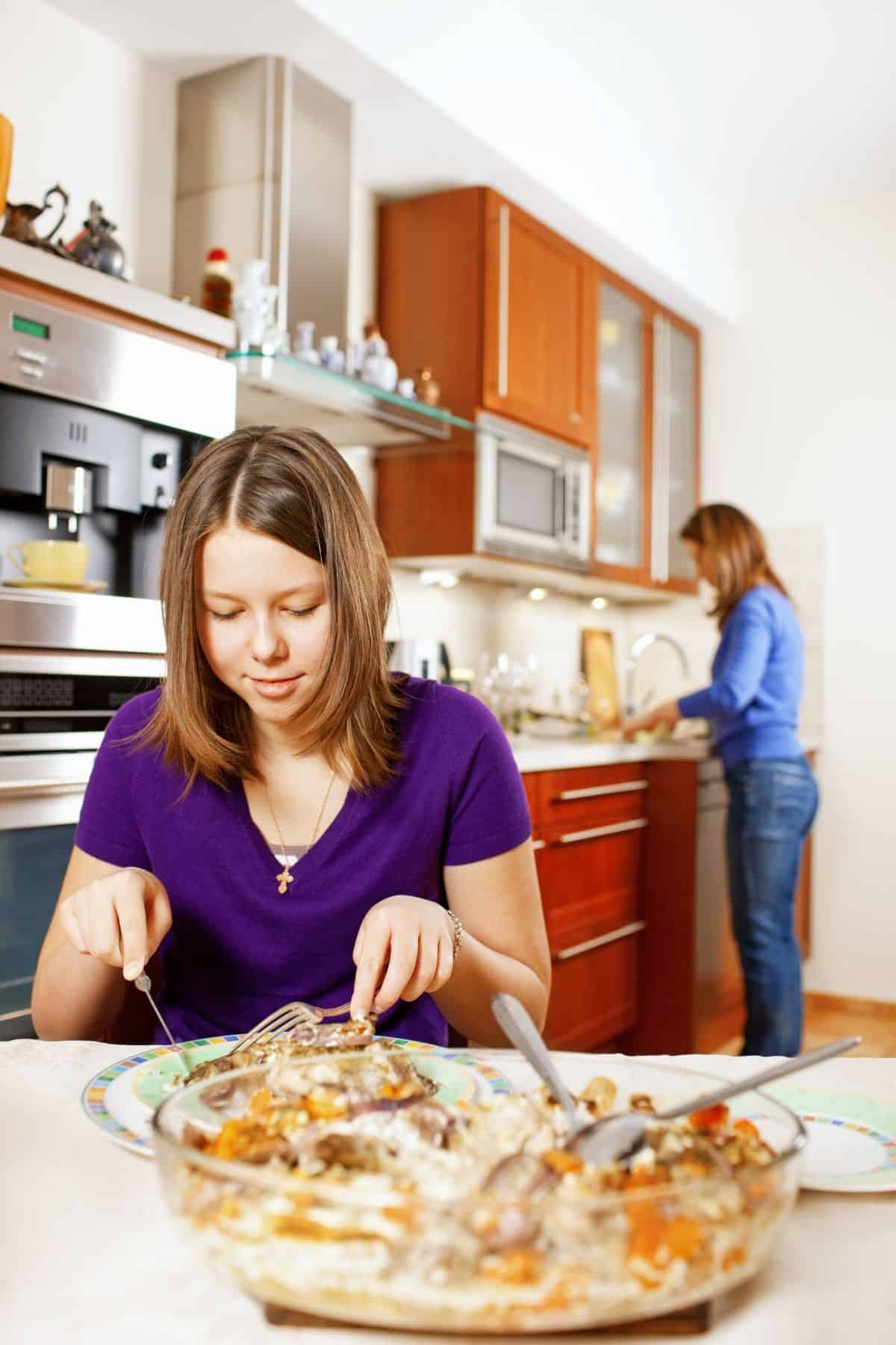 a girl eating in the kitchen