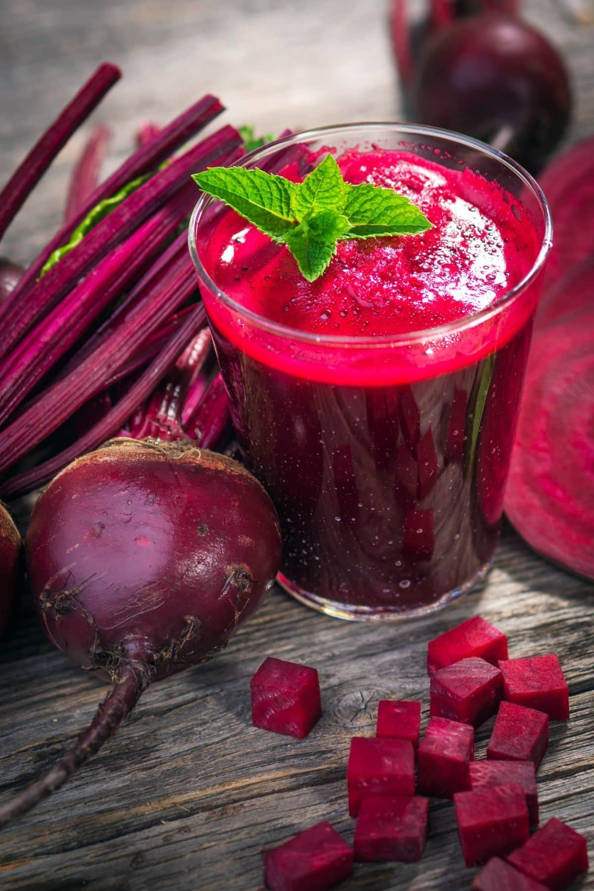 glass of beet juice on a table with fresh beets