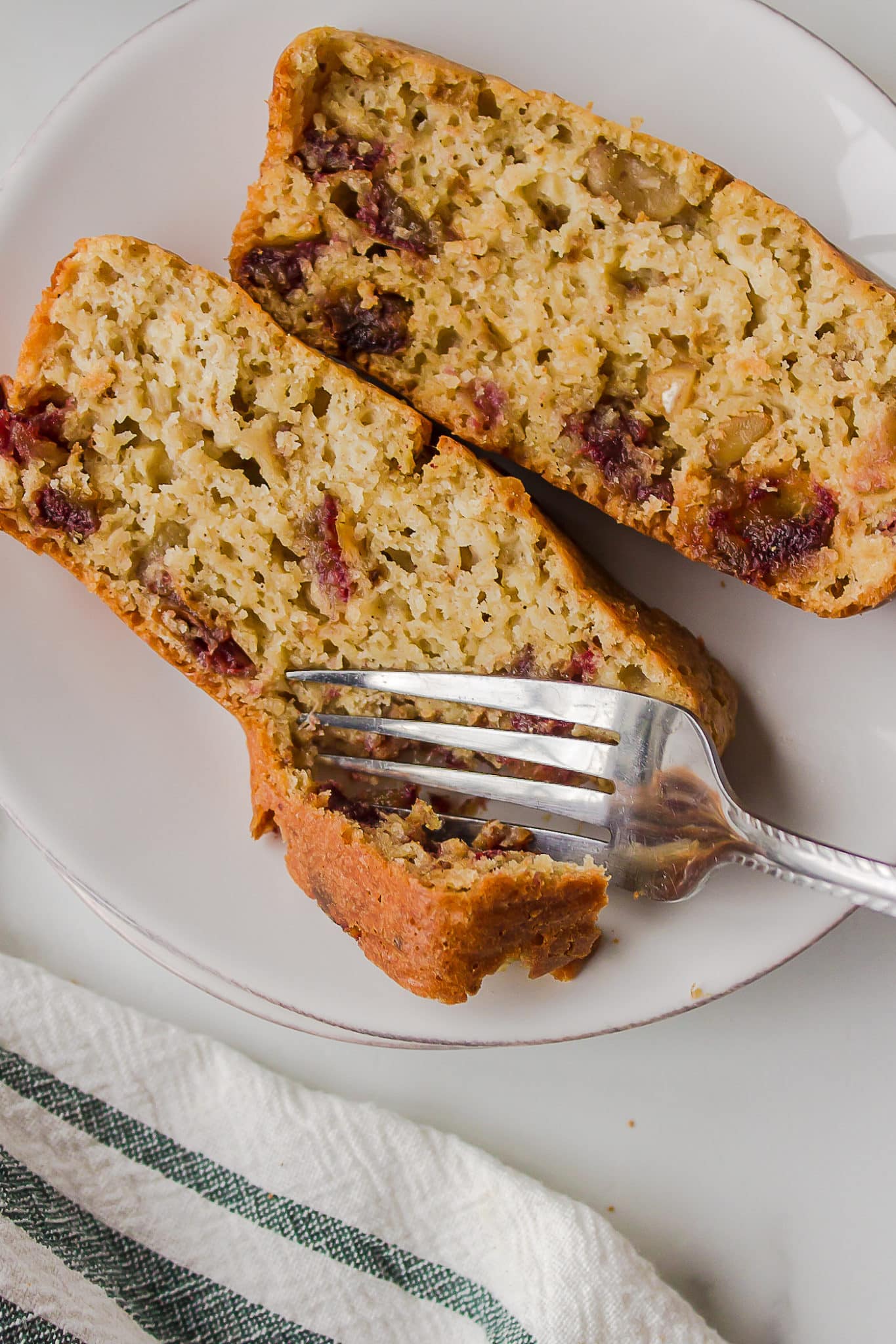 two slices of date walnut bread on plate with fork.