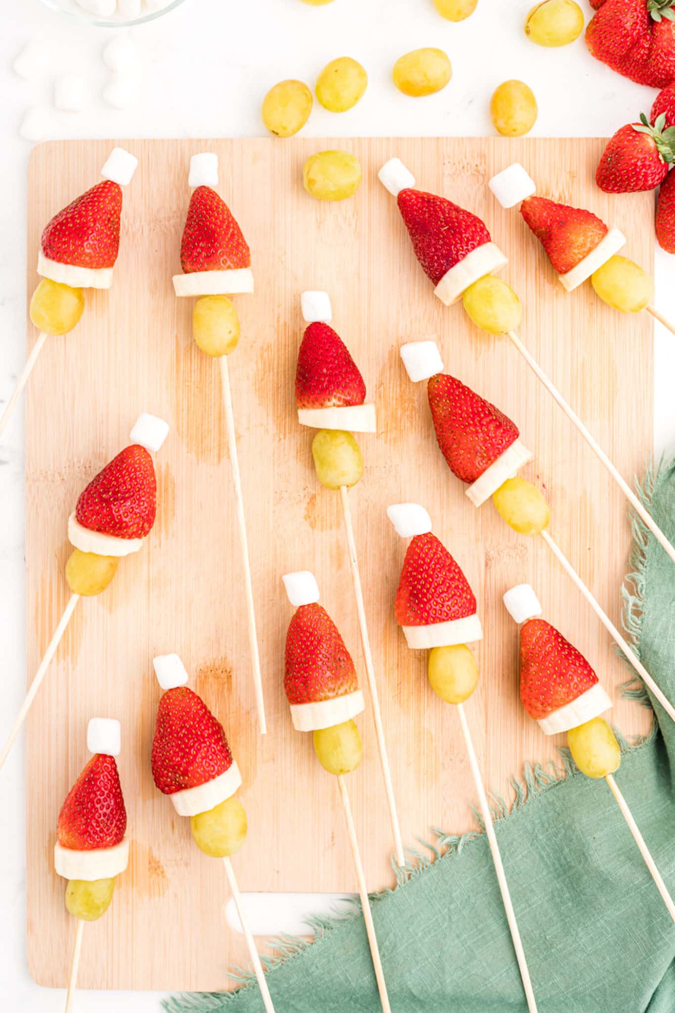 strawberry fruit kabobs on a cutting board.