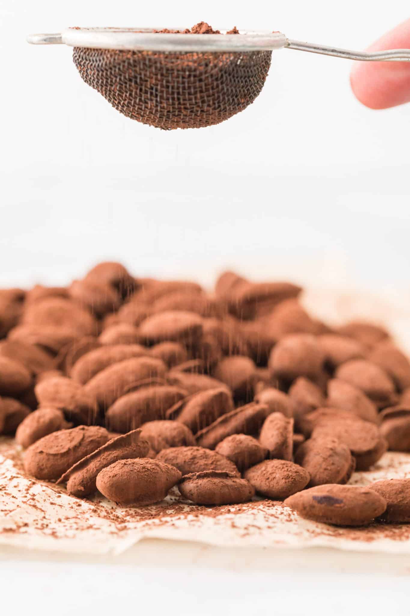 sifting cocoa powder onto almonds