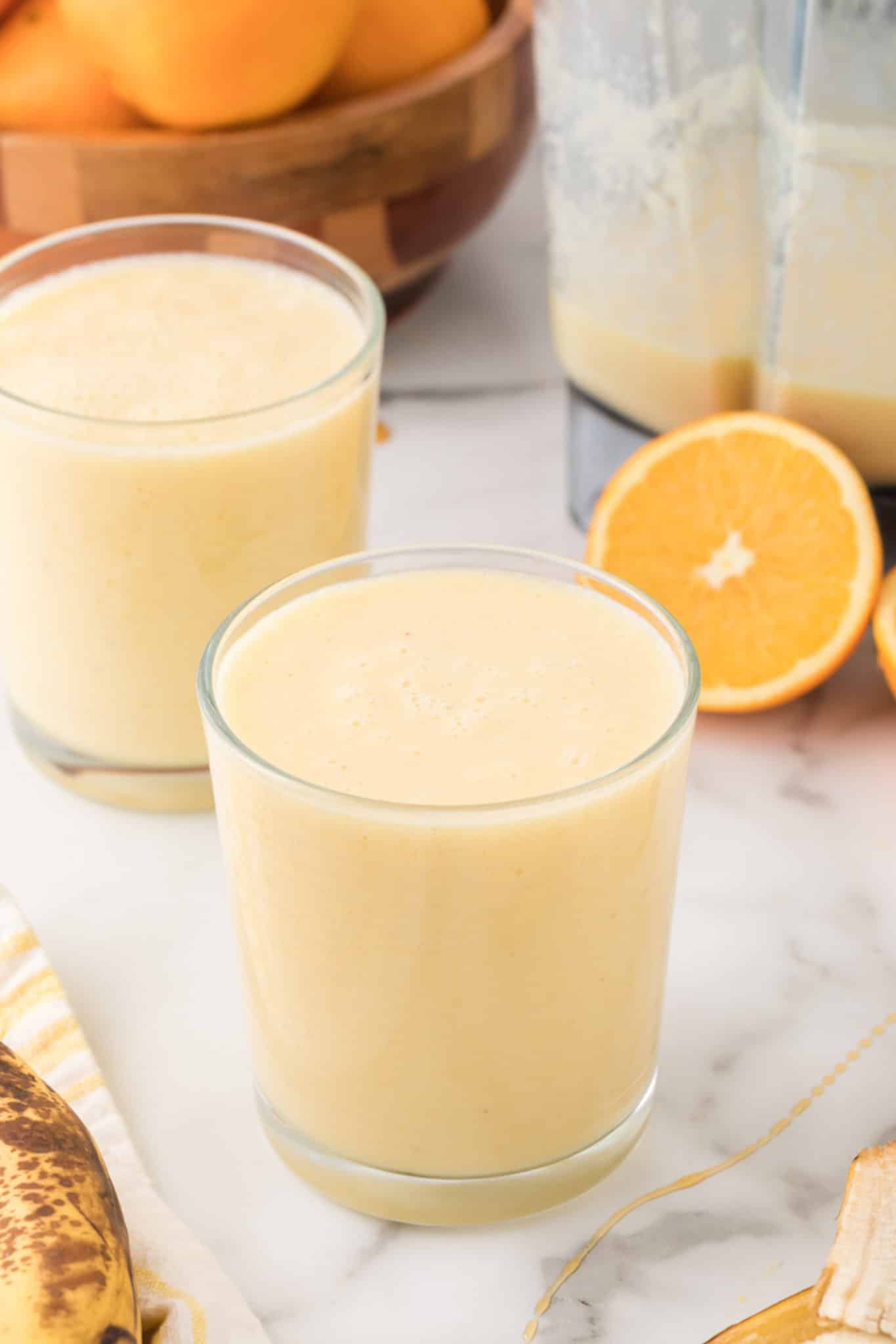 two glasses of orange smoothie on table