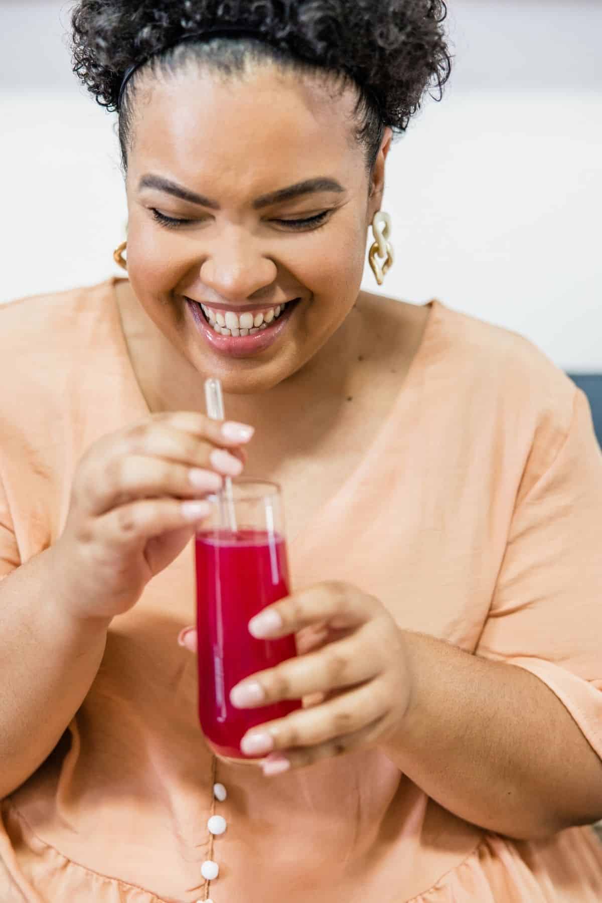 woman drinking a glass of beet juice