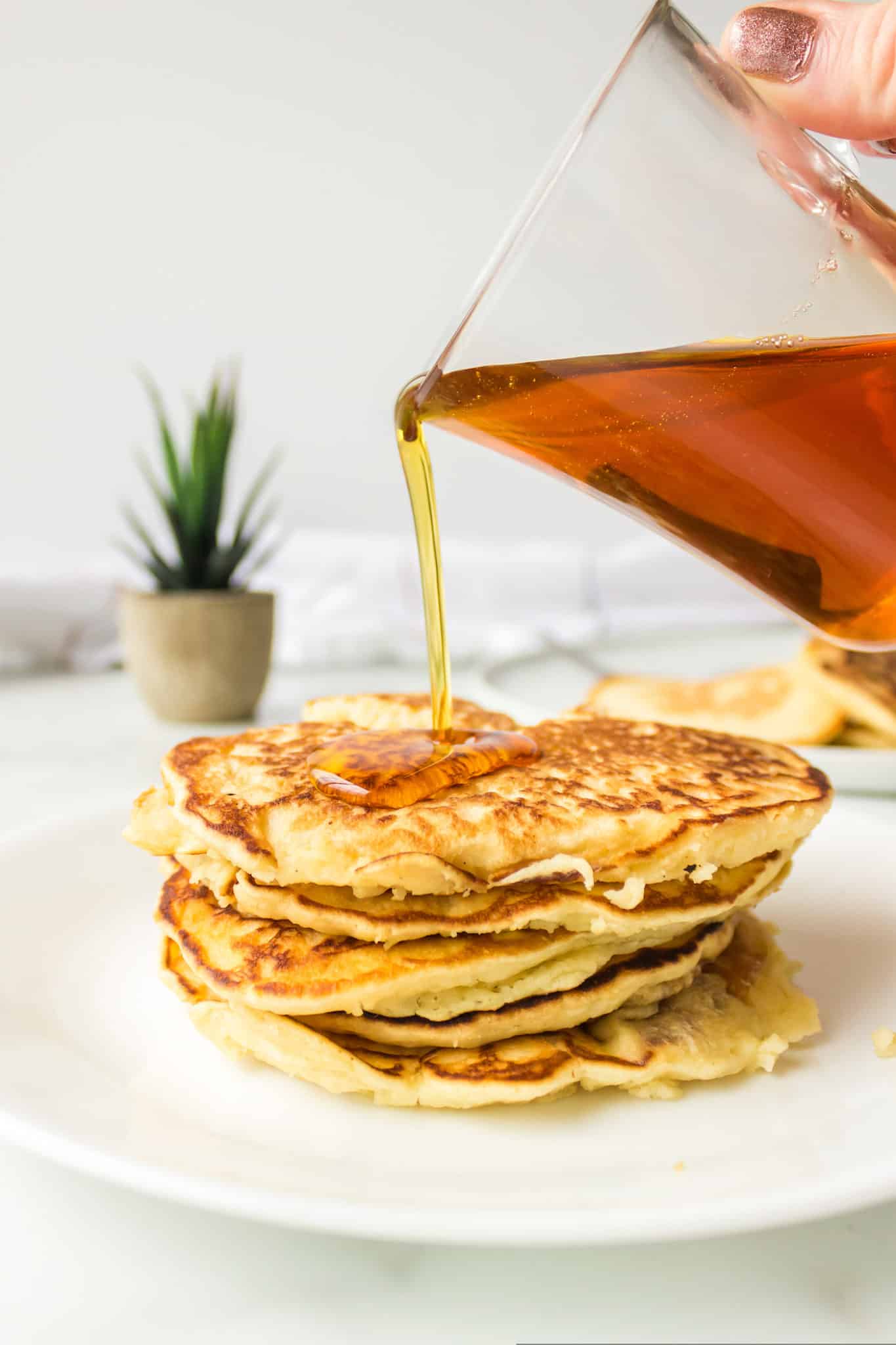 pouring syrup onto rice flour pancakes.