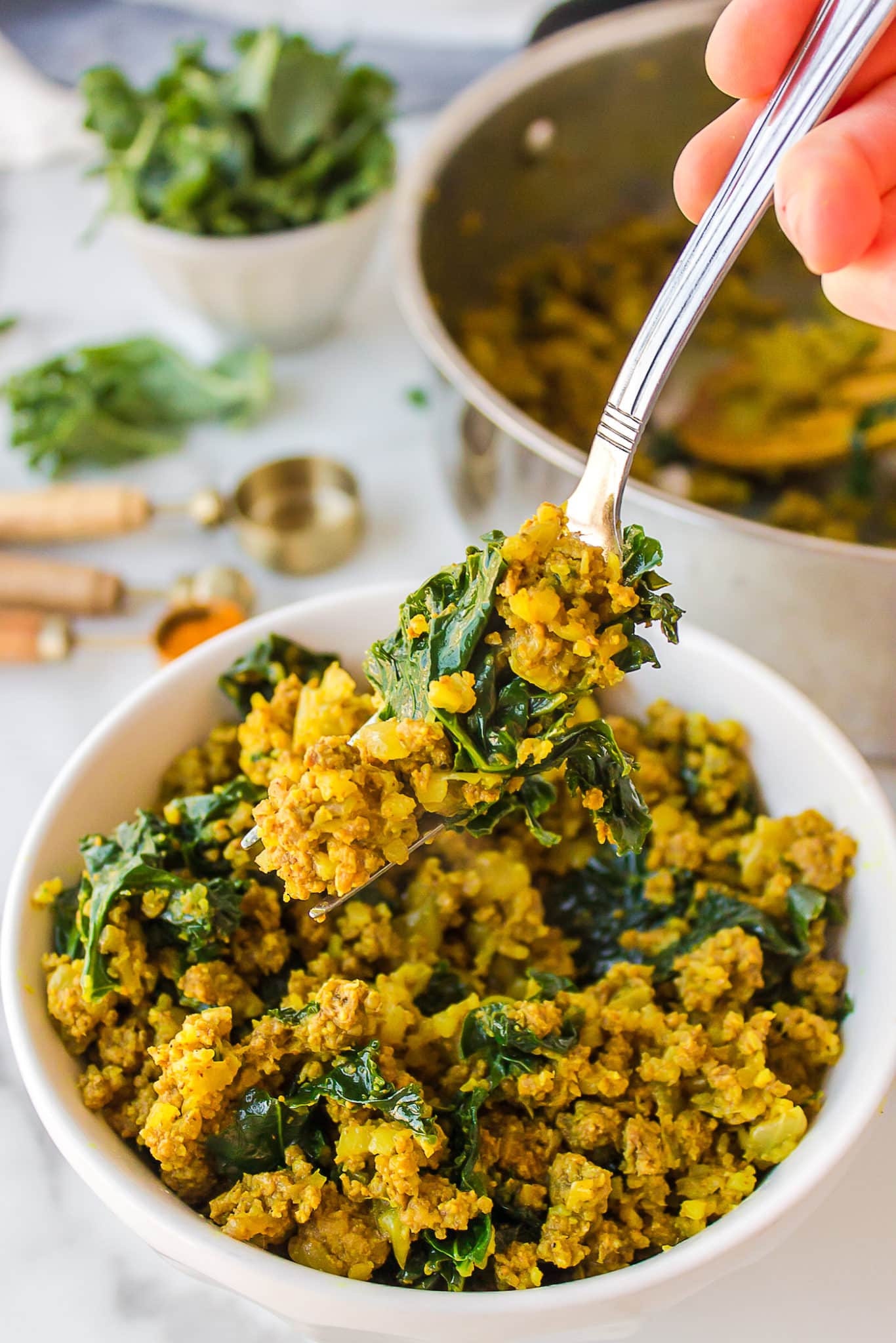 ground bison with kale on a fork.