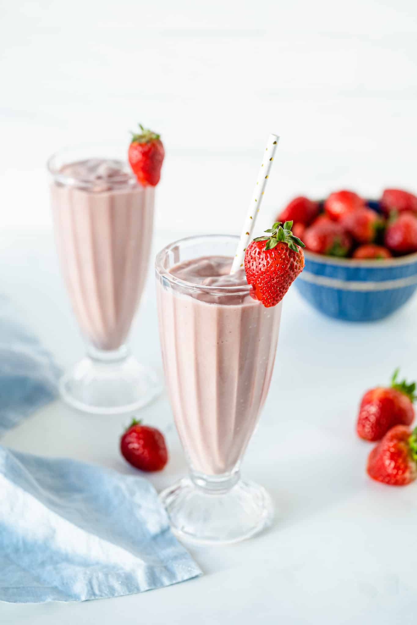 two glasses of beet smoothie with fresh strawberries.