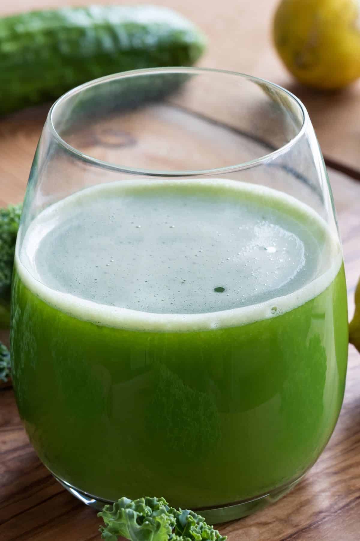 freshly juiced kale juice in glass on table.