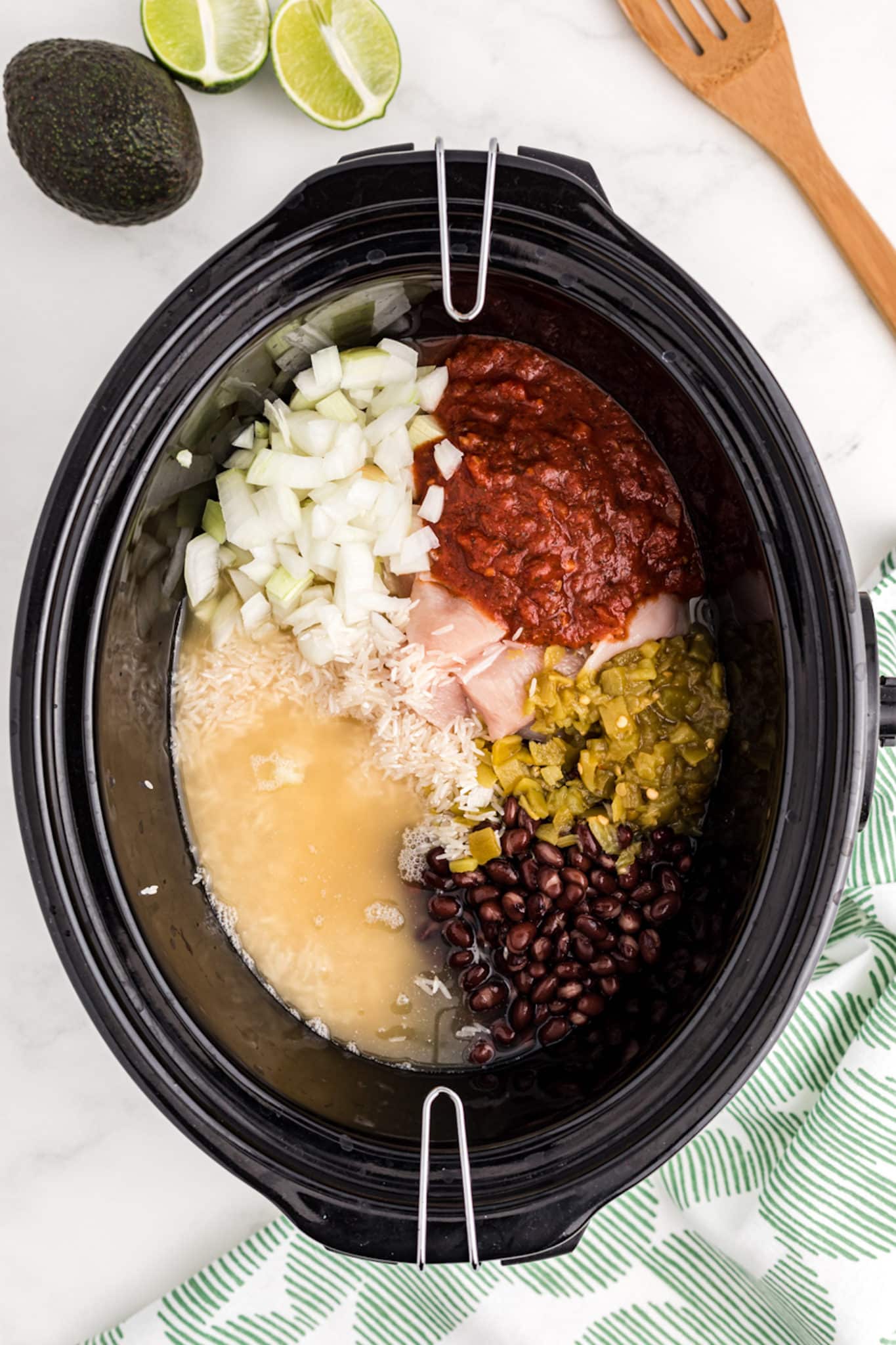 a crockpot with chicken, rice, salsa, and beans.
