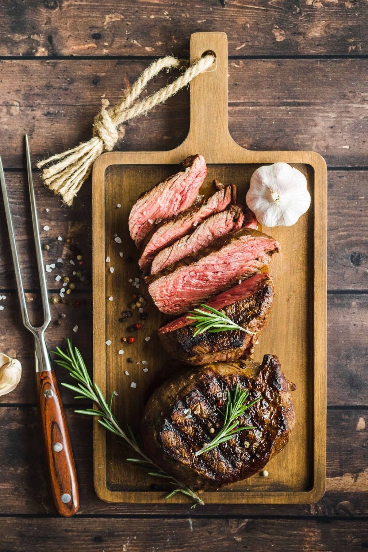 sliced steak on a table on cutting board.