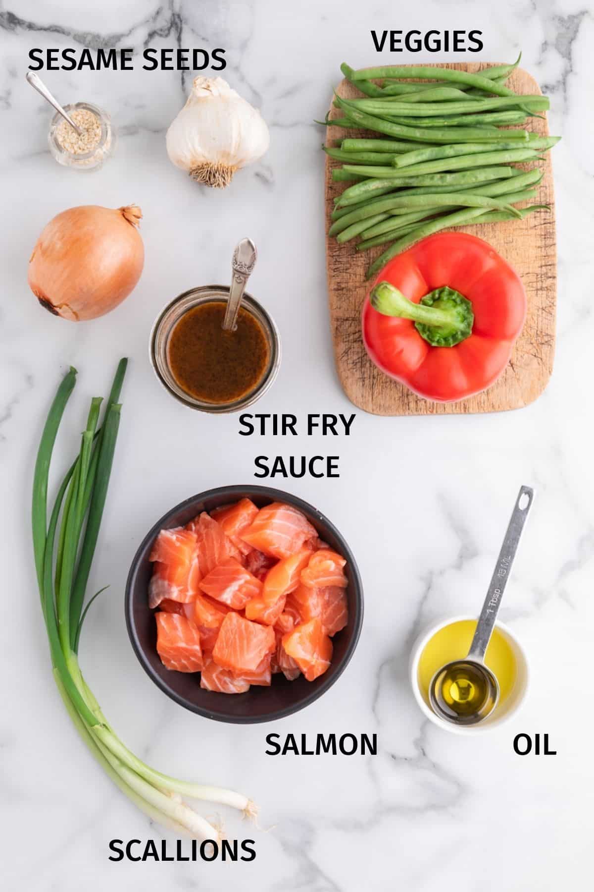 Salmon stir fry ingredients set out on a white marble surfce.