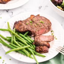 a sliced steak with green beans