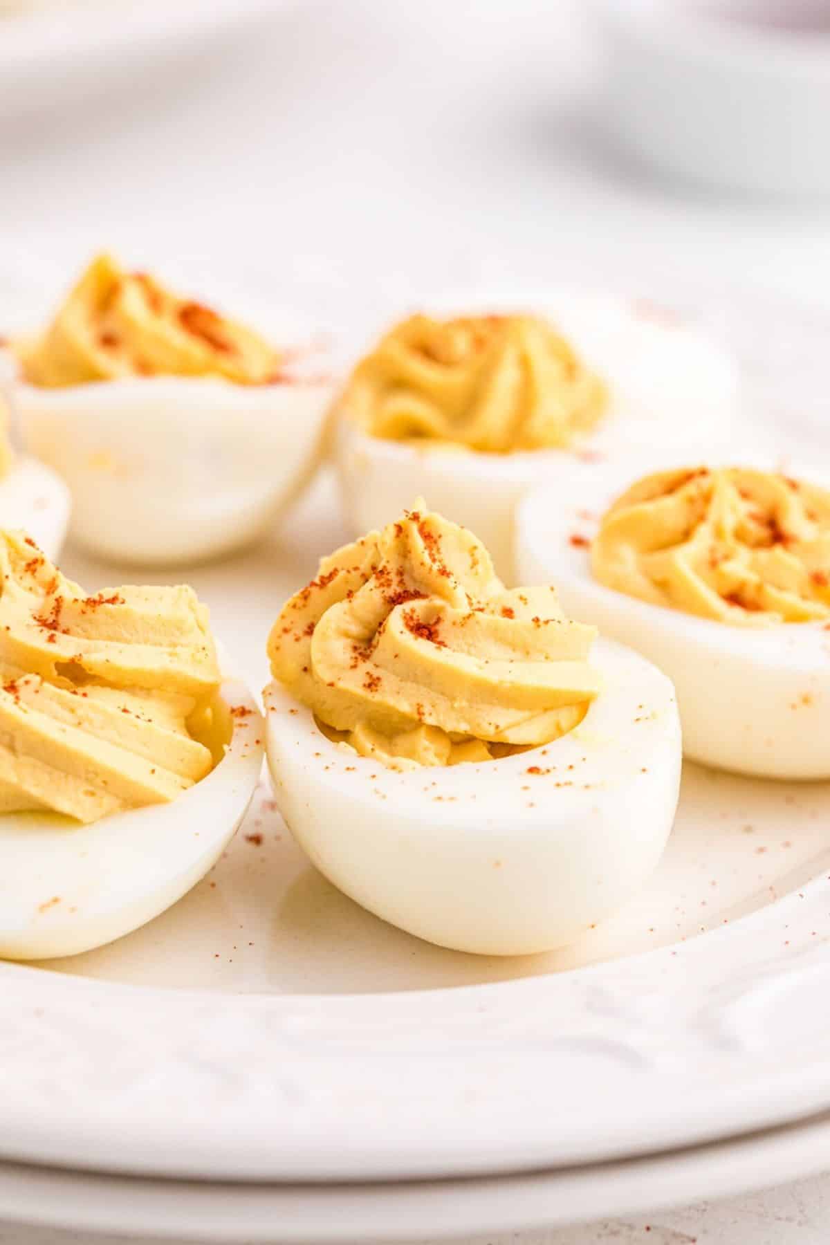 Deviled eggs with paprika on a plate.