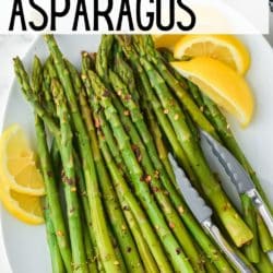 Instant Pot asparagus on a white serving platter surrounded by lemon wedges.