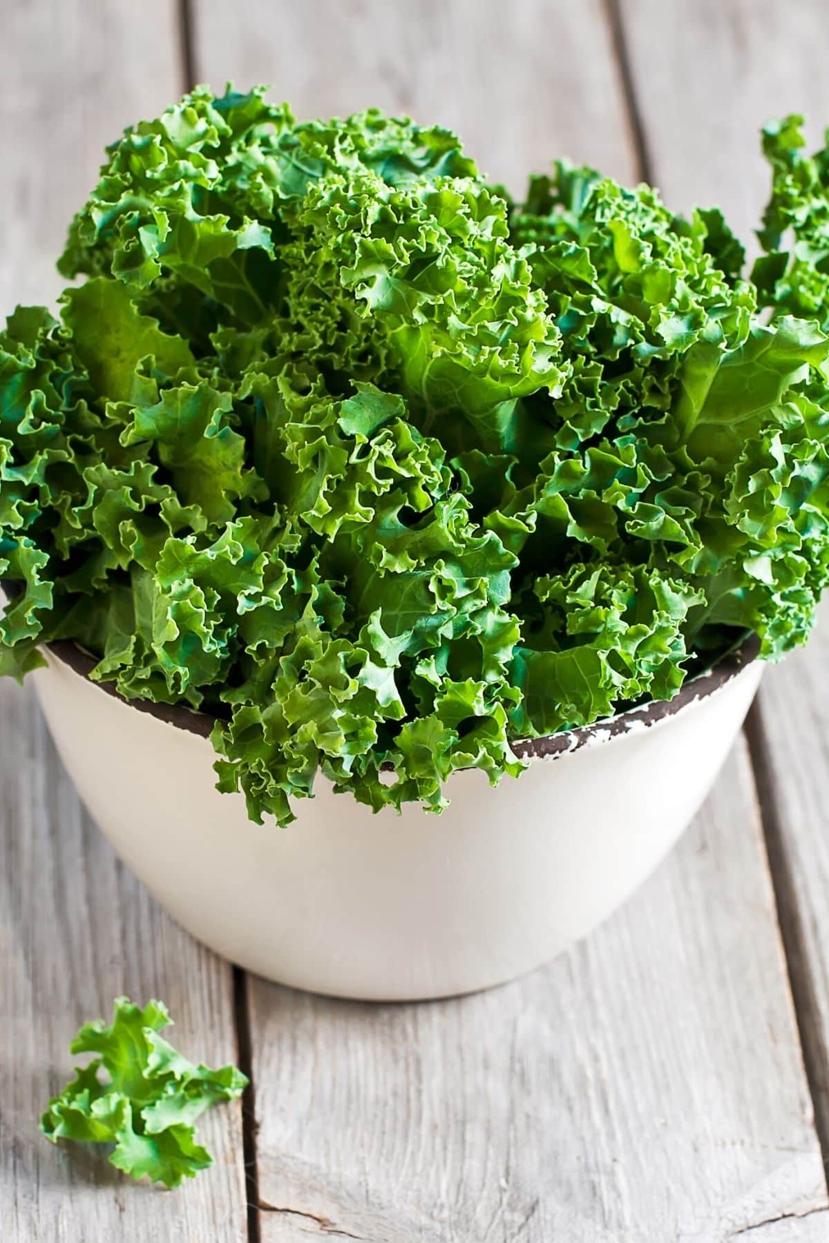 kale in a white bowl on a table.
