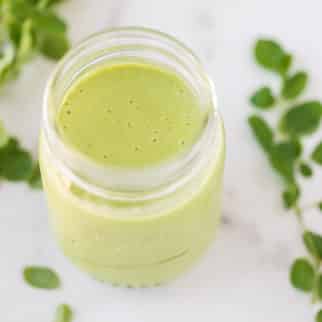 Top view of a jar of moringa smoothie on a white background.