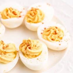 deviled eggs with paprika in a circle on a plate