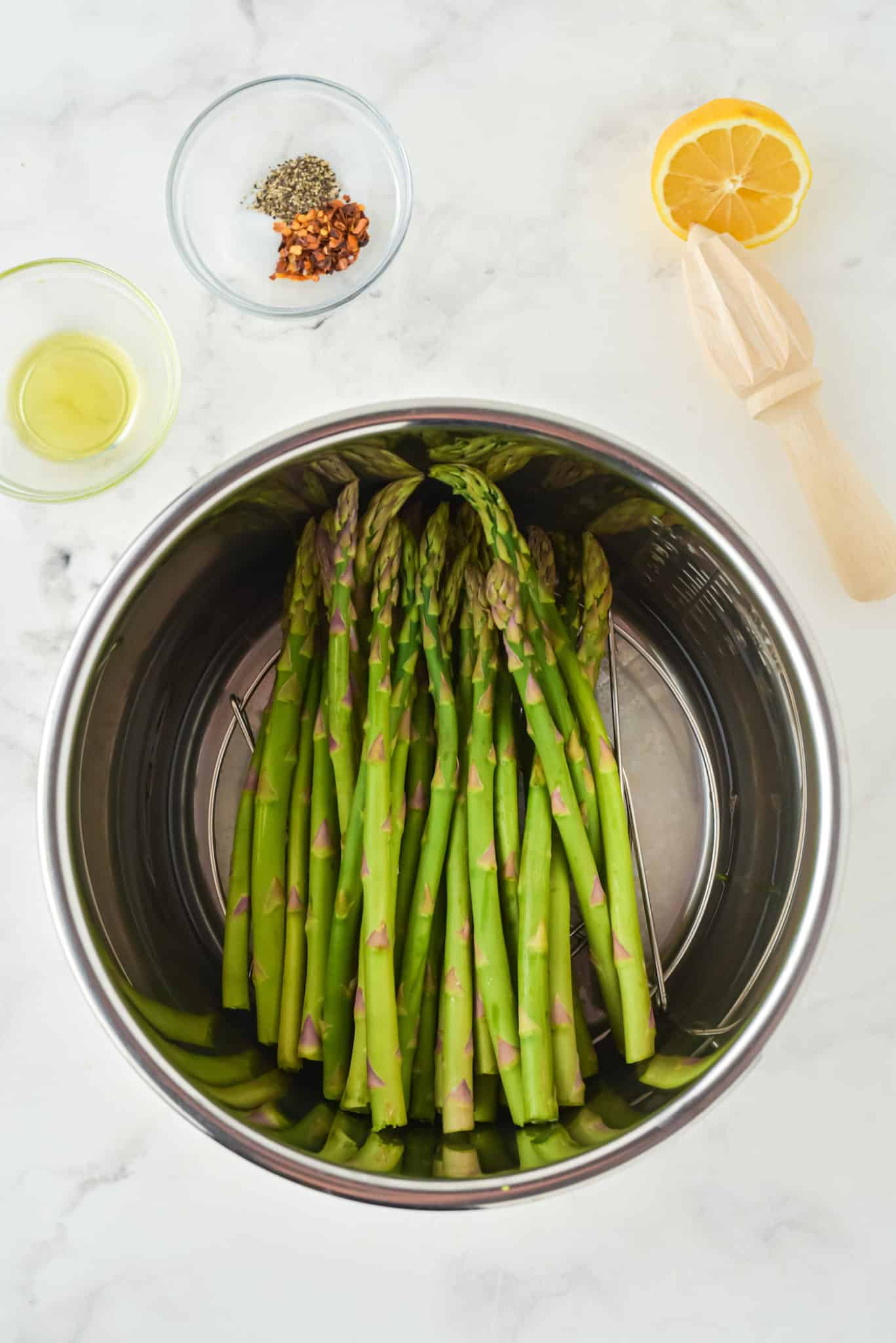 Fresh asparagus on a trivet inside an Instant Pot insert.