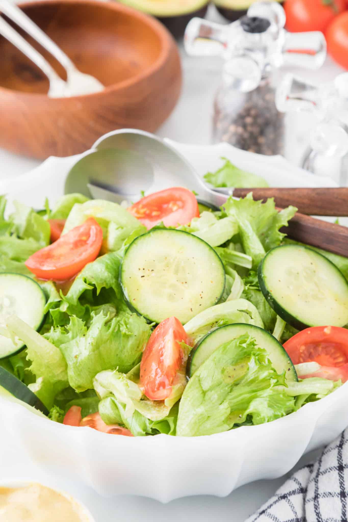 green salad with tomato and cucumbers dressed with honey mustard dressing.