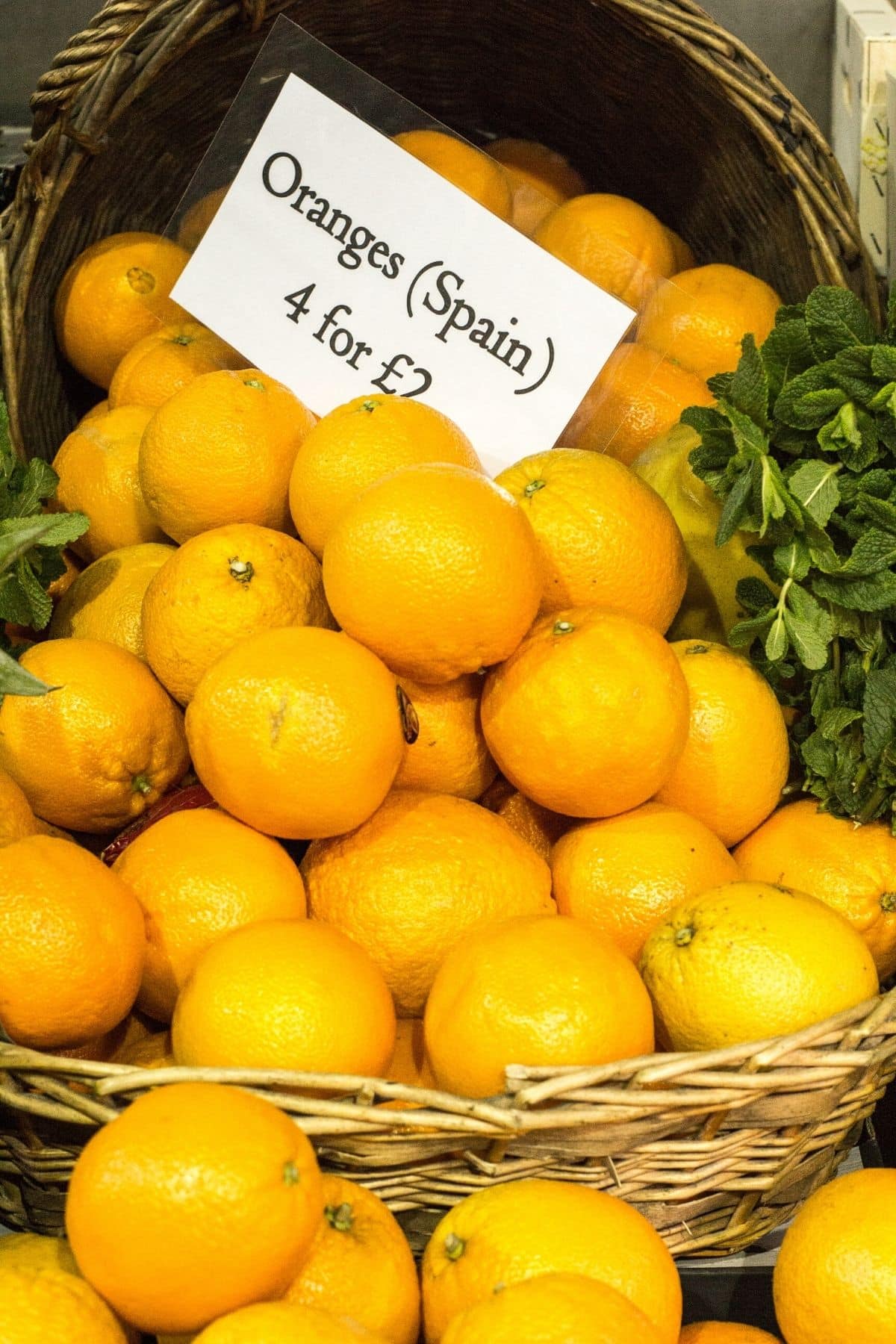 spanish oranges in a basket with price tag.